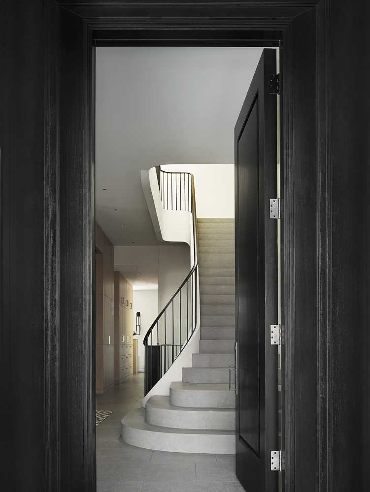 The jet-black front door serves as a transition between the classic exterior and the contemporary interiors within.