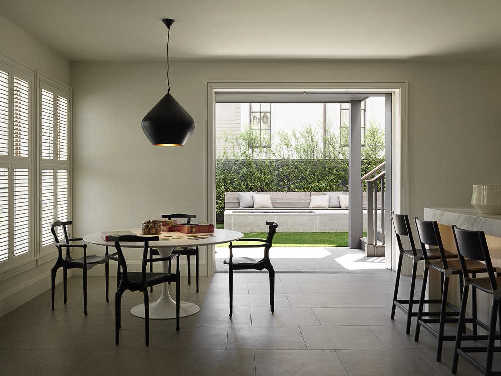 A casual dining area that opens to the yard, where an outdoor firepit and benches expand the living spaces.