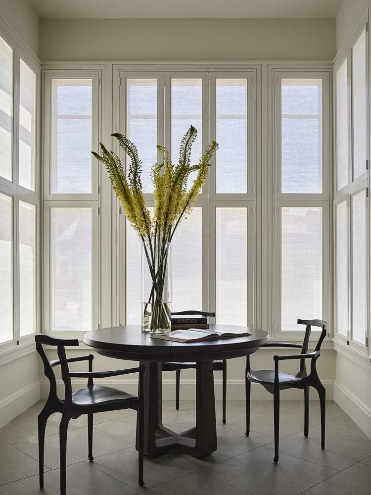 The table and chairs enjoy the natural light from the windows on three sides, and when needed, the table can be expanded into a large 12-person dining table.