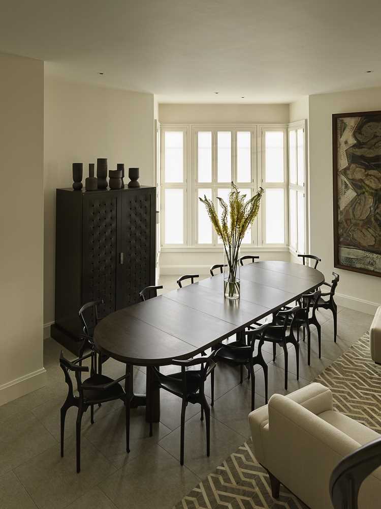 The table and chairs enjoy the natural light from the windows on three sides, and when needed, the table can be expanded into a large 12-person dining table.