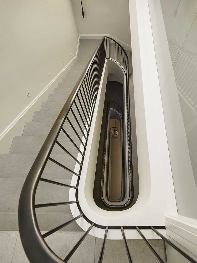 A contemporary staircase with a metal railing connects the four floors of this home.