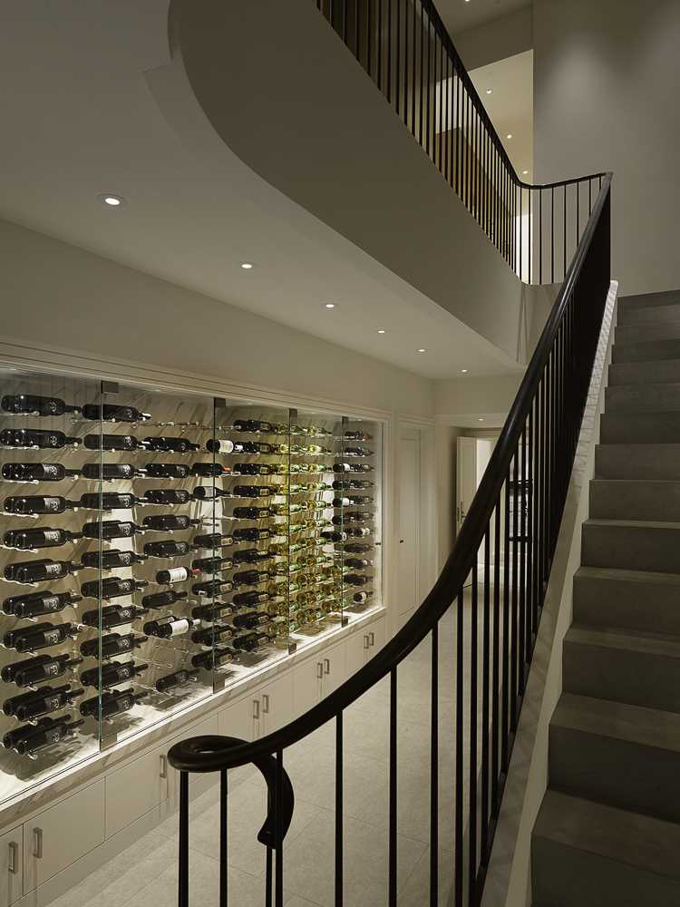 A contemporary staircase and a wine storage wall.