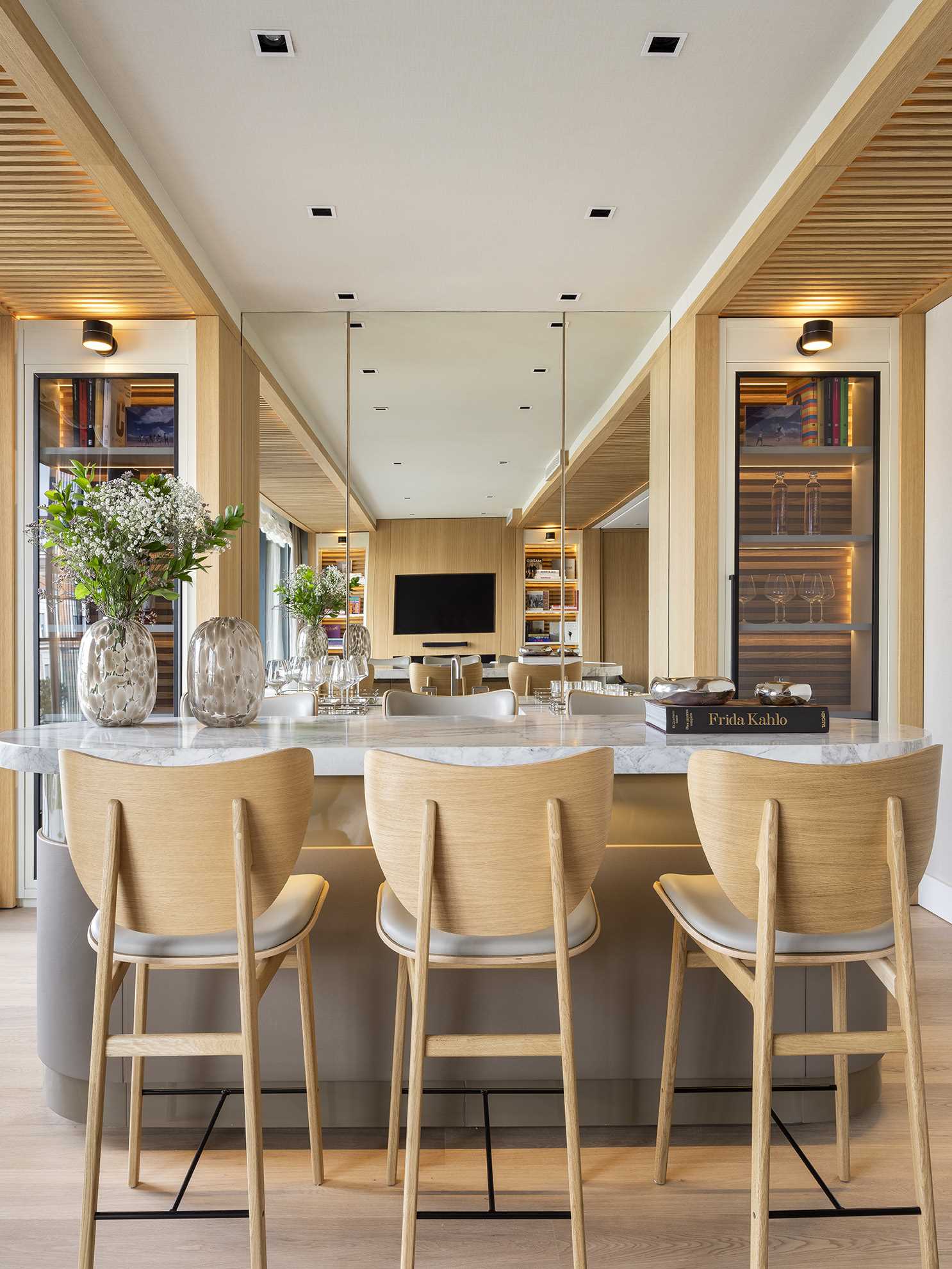 The bar area includes a pair of liquor cabinets on either side of a mirrored section, making the room feel larger than it is.