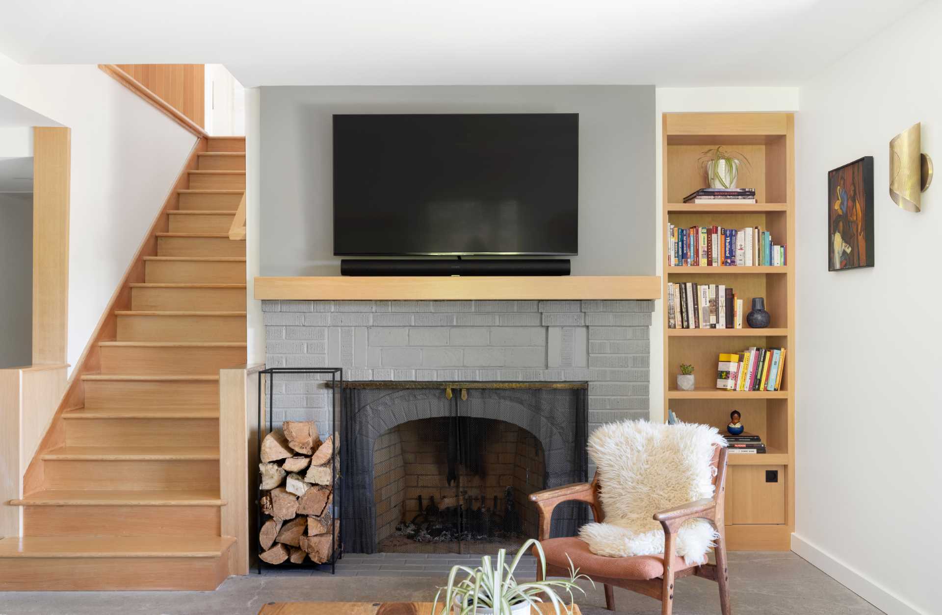 A modern family room with a fireplace and built-in wood shelving.