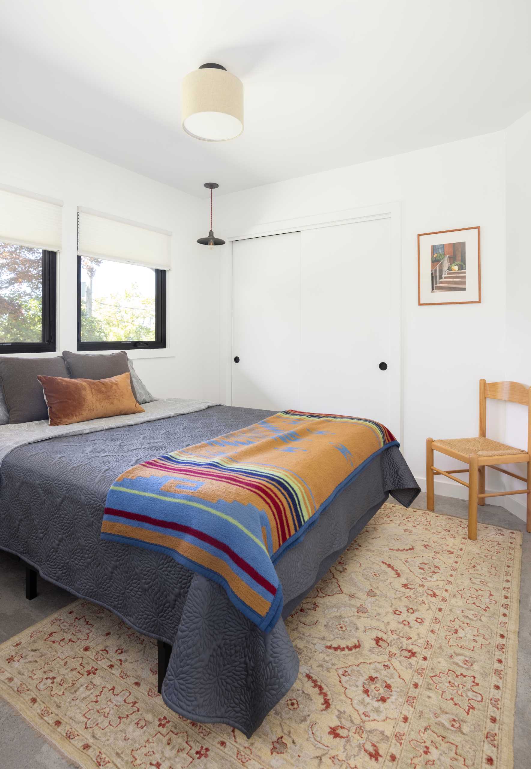 A remodeled bedroom with white walls and concrete floors.