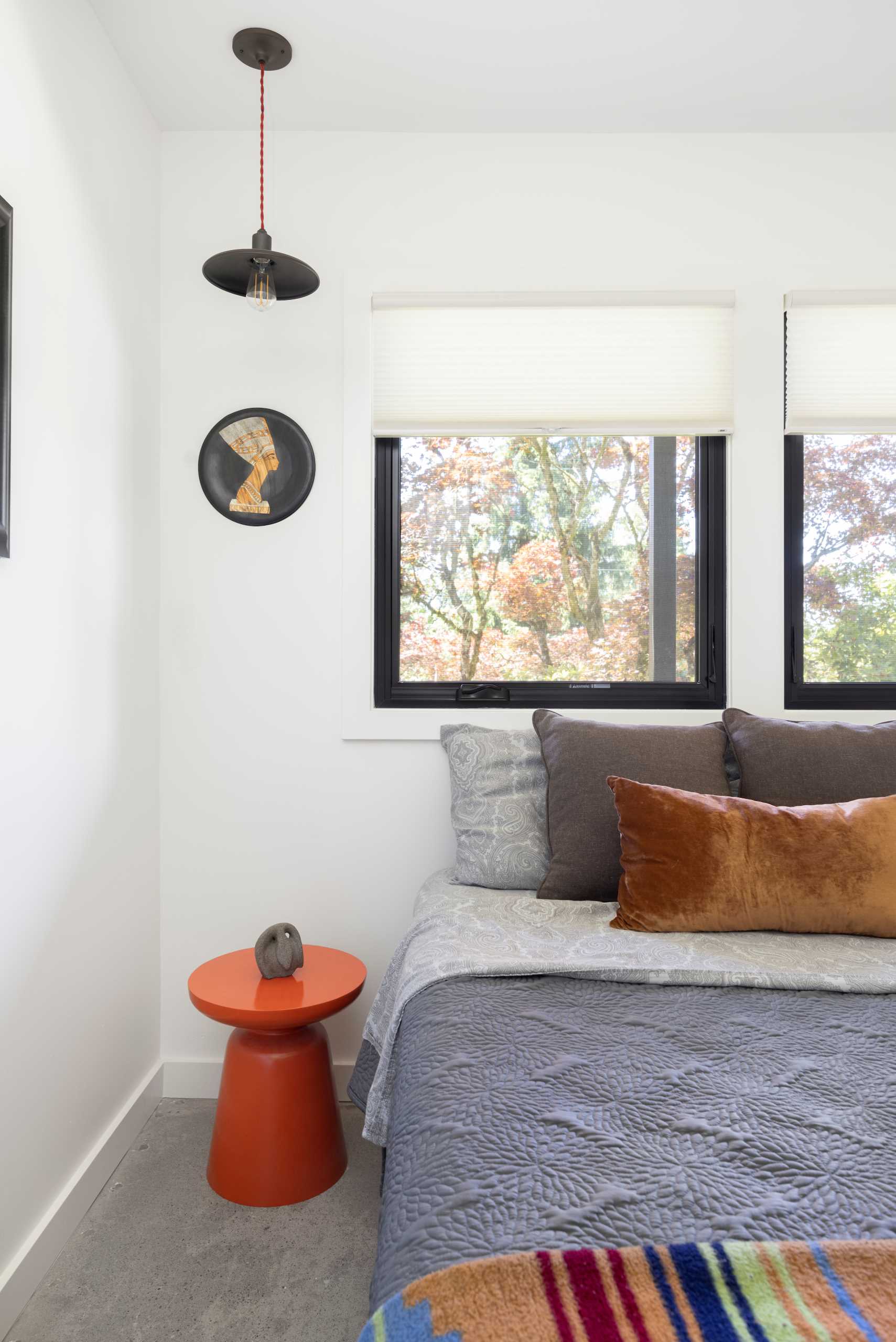 A remodeled bedroom with white walls and concrete floors.