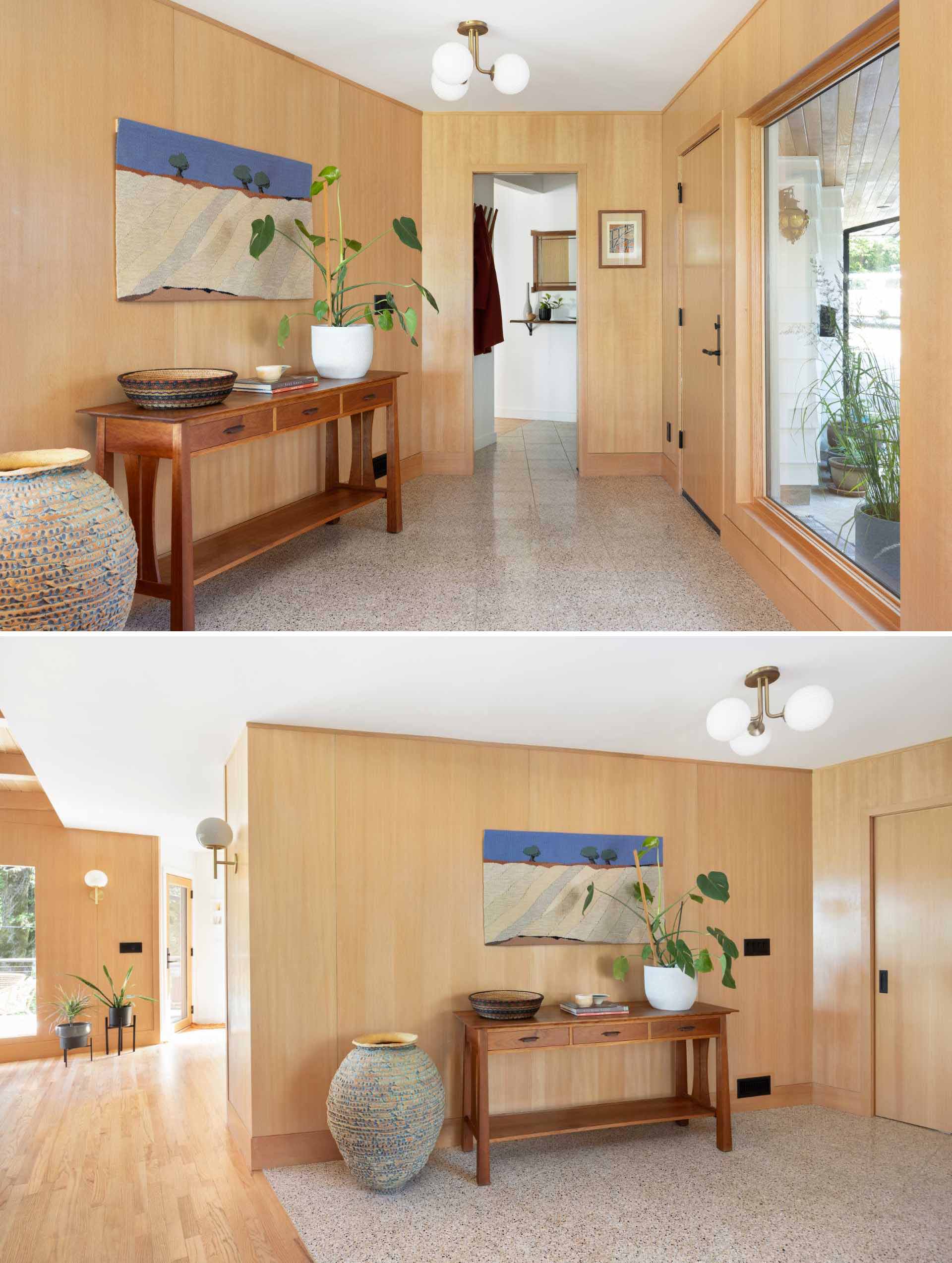 This updated entryway is lined with wood and includes a large window and tiled flooring.