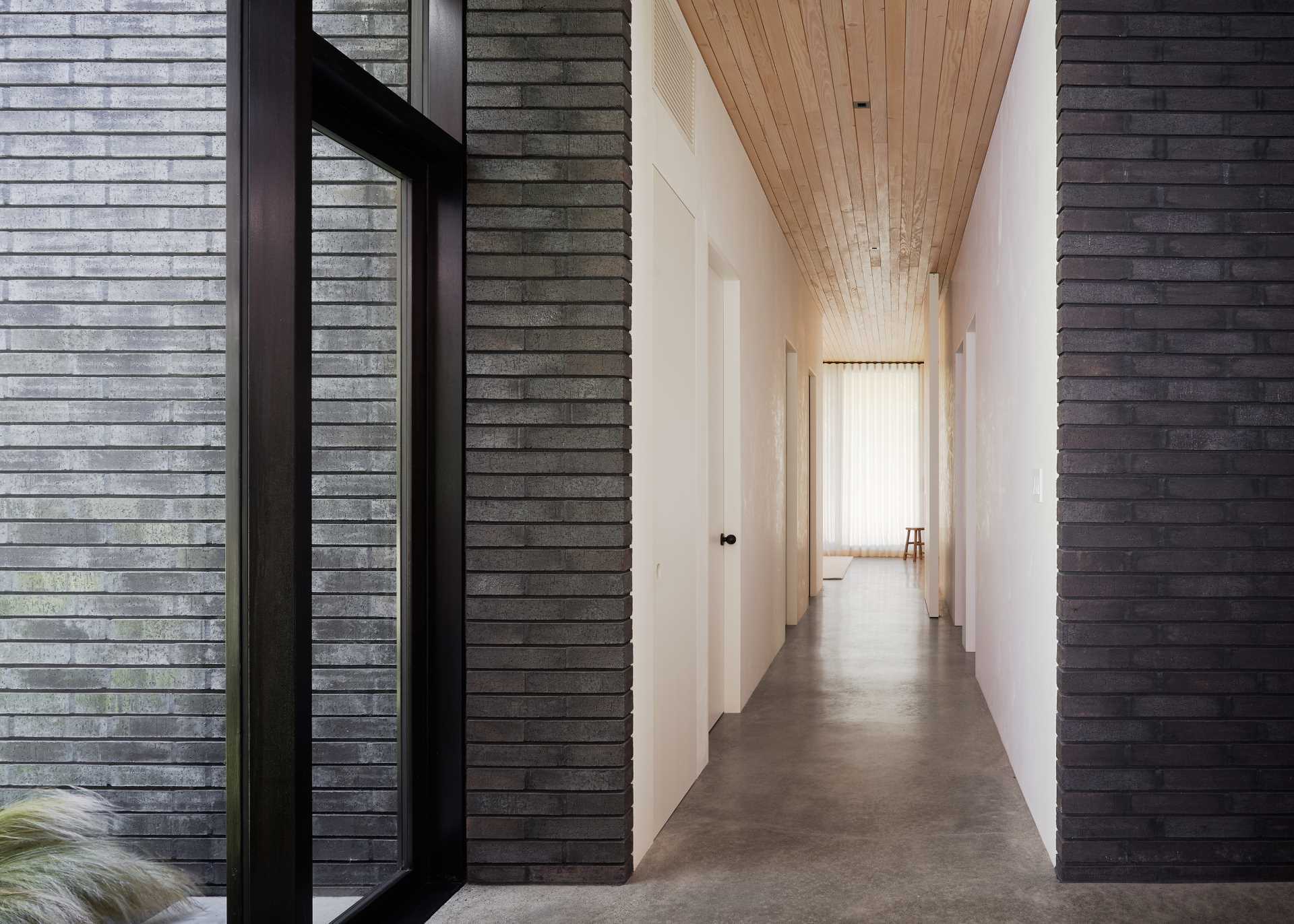 A long hallway in this modern home leads from the entryway to the bedrooms and bathrooms.