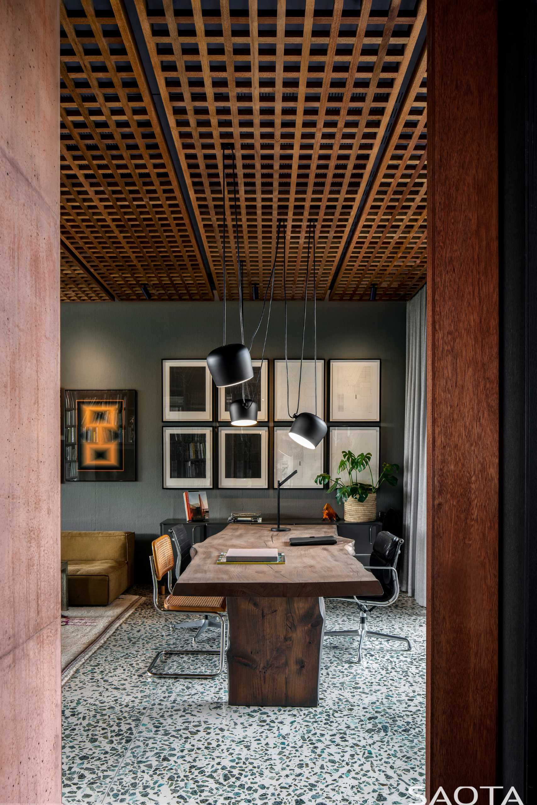 Современный домашний офис с видом на сад включает в себя гостиную, серые стены и деревянный стол.