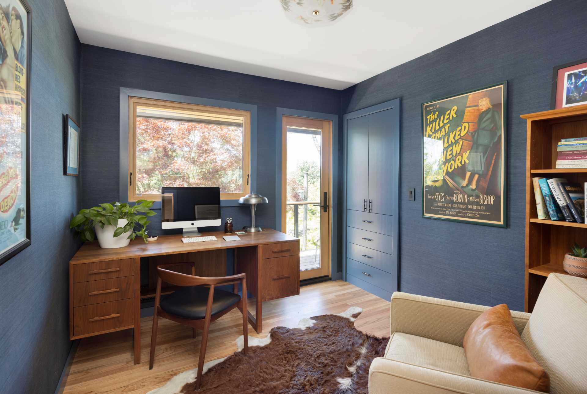 A modern home office has blue walls and wood floors, while the furniture reflects the original mid-century modern aesthetic.