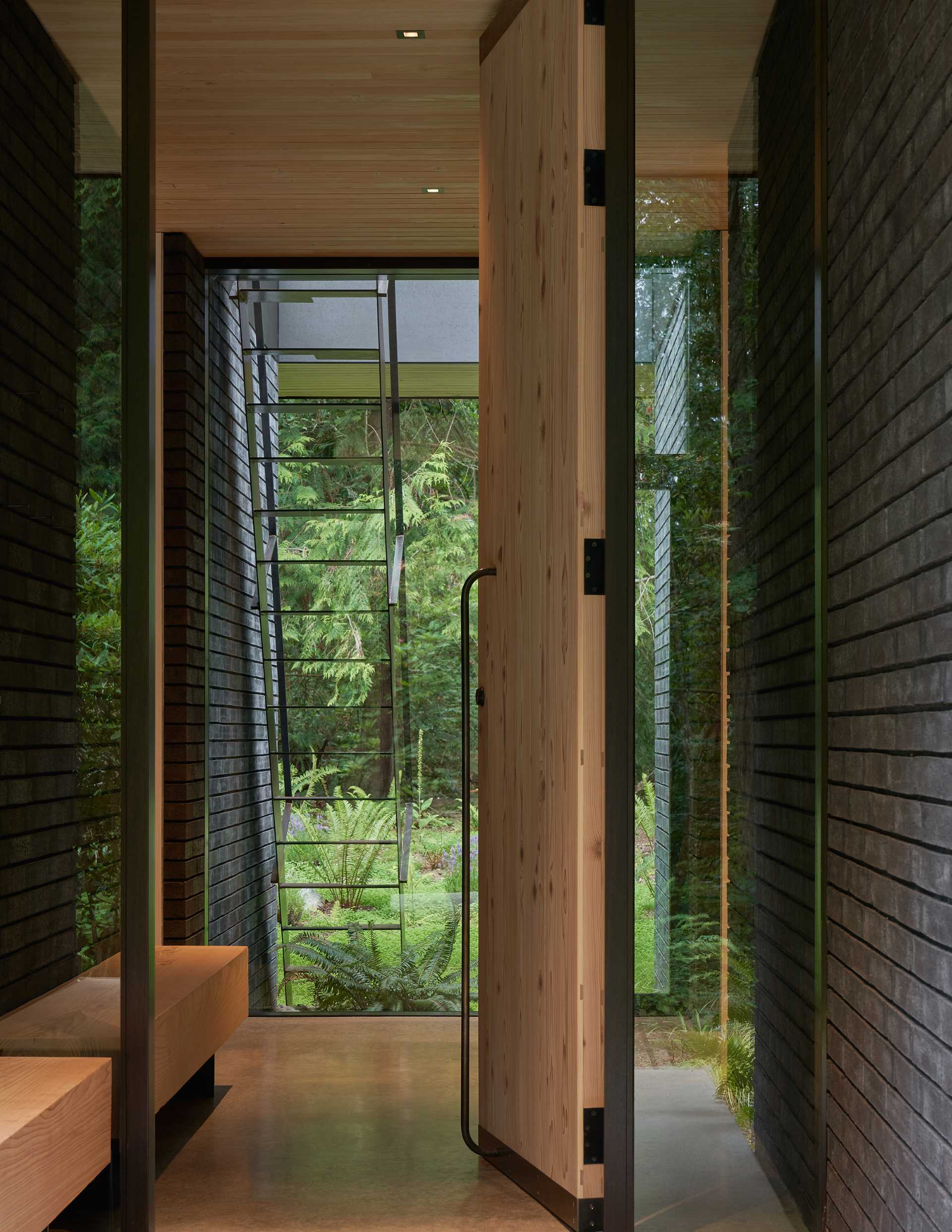 A modern home with a pivoting cedar front door.