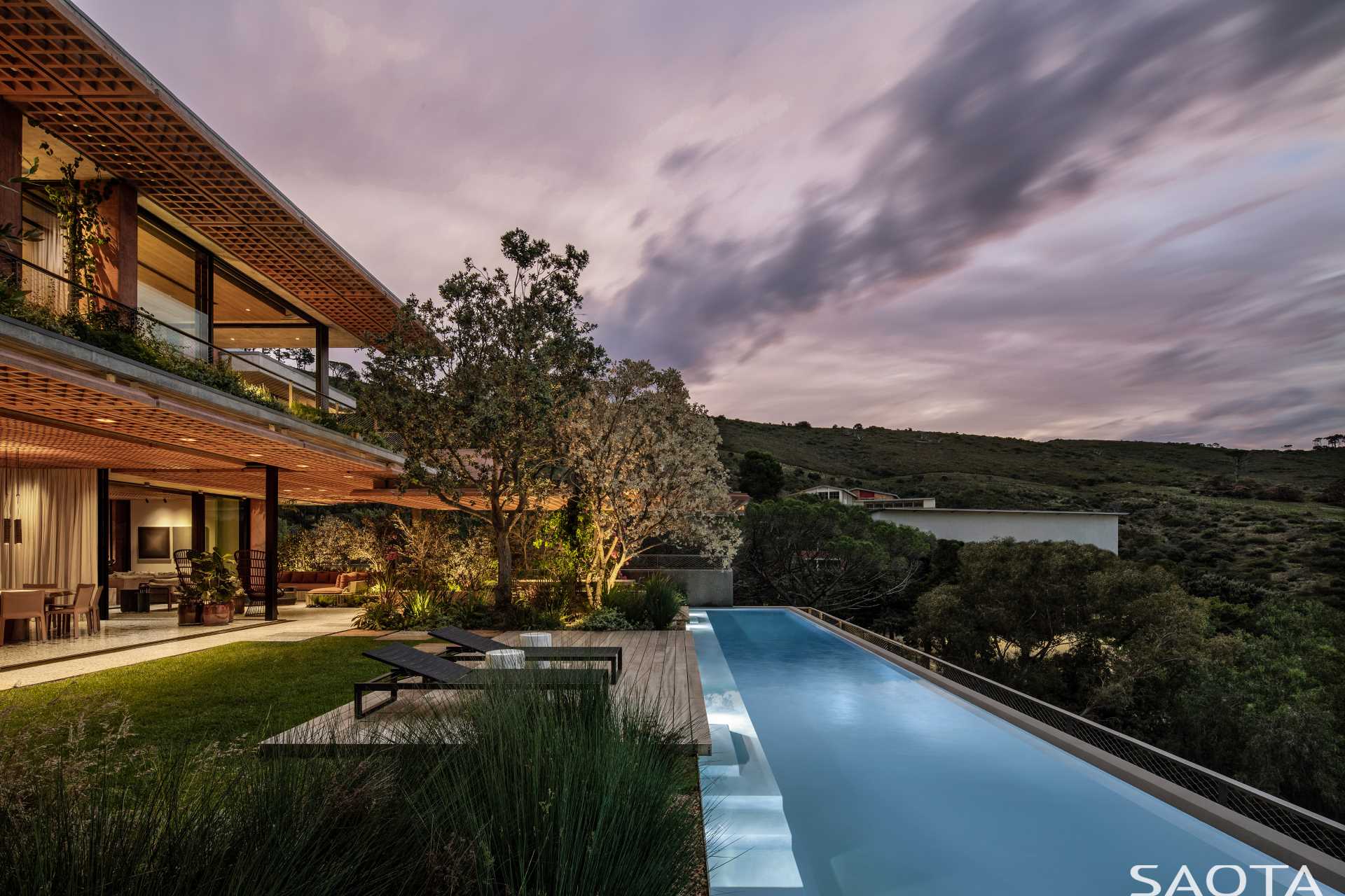 This modern home features a swimming pool and outdoor spaces, some of which are paved in Rustenburg granite and local sandstone.