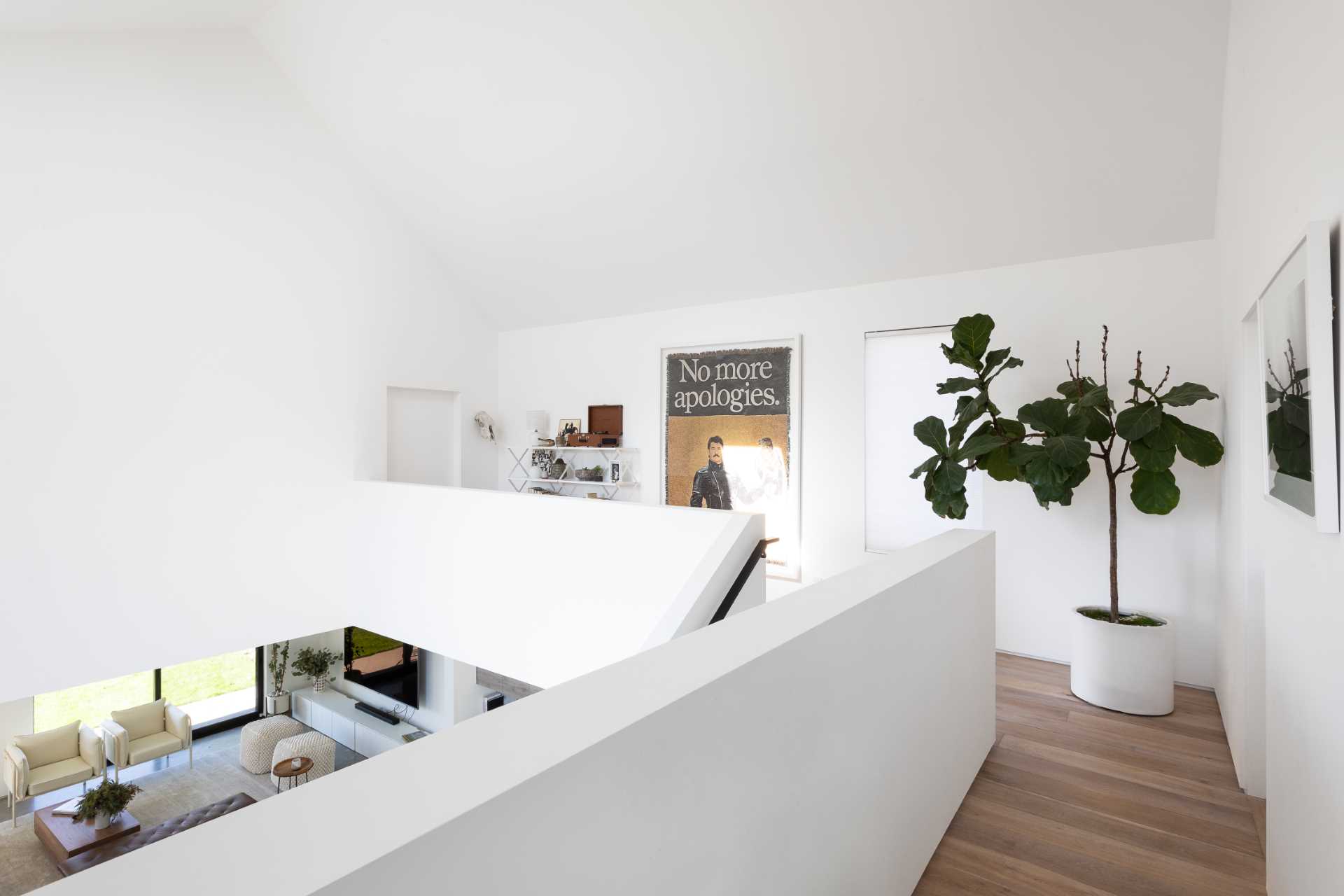 A modern home with a library bridge that leads to the bedrooms.