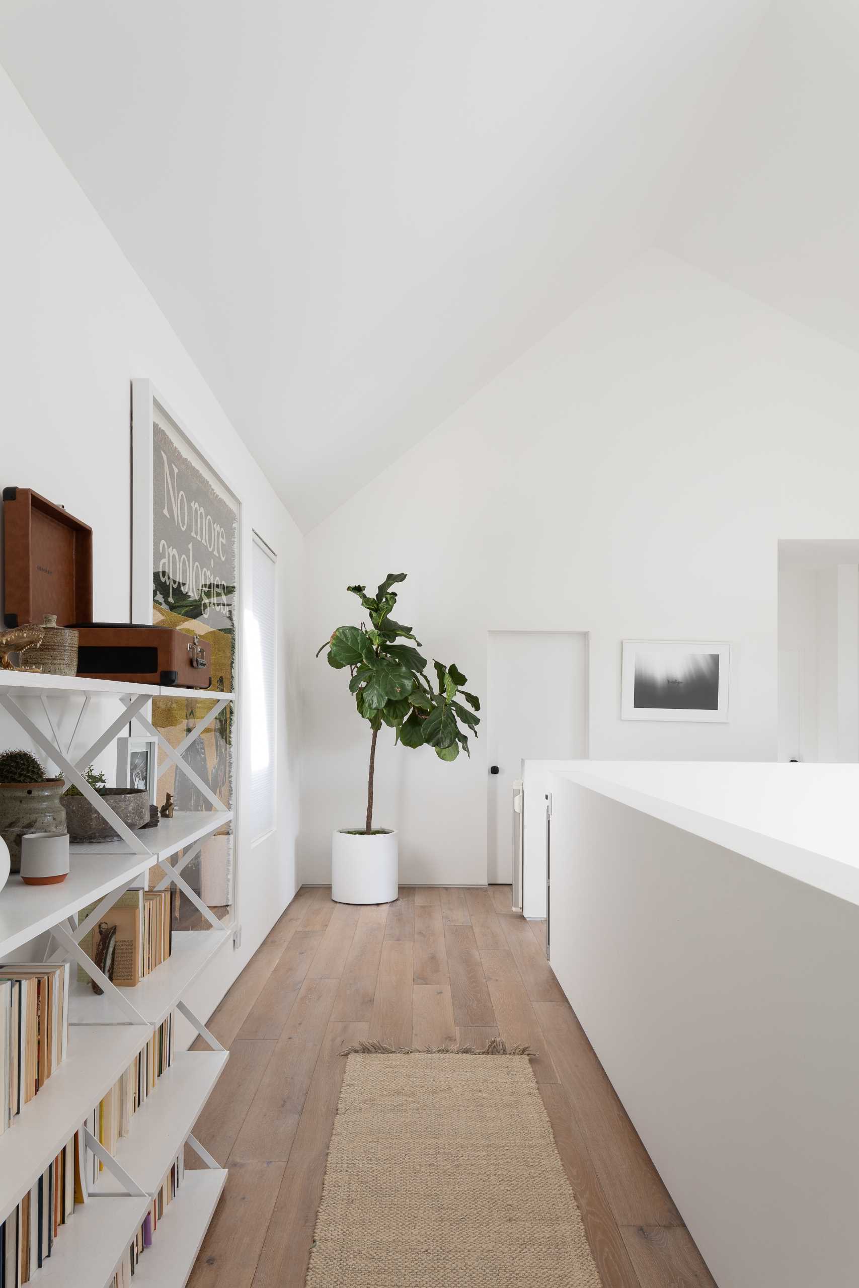 A modern interior with wood floors and bookshelves.