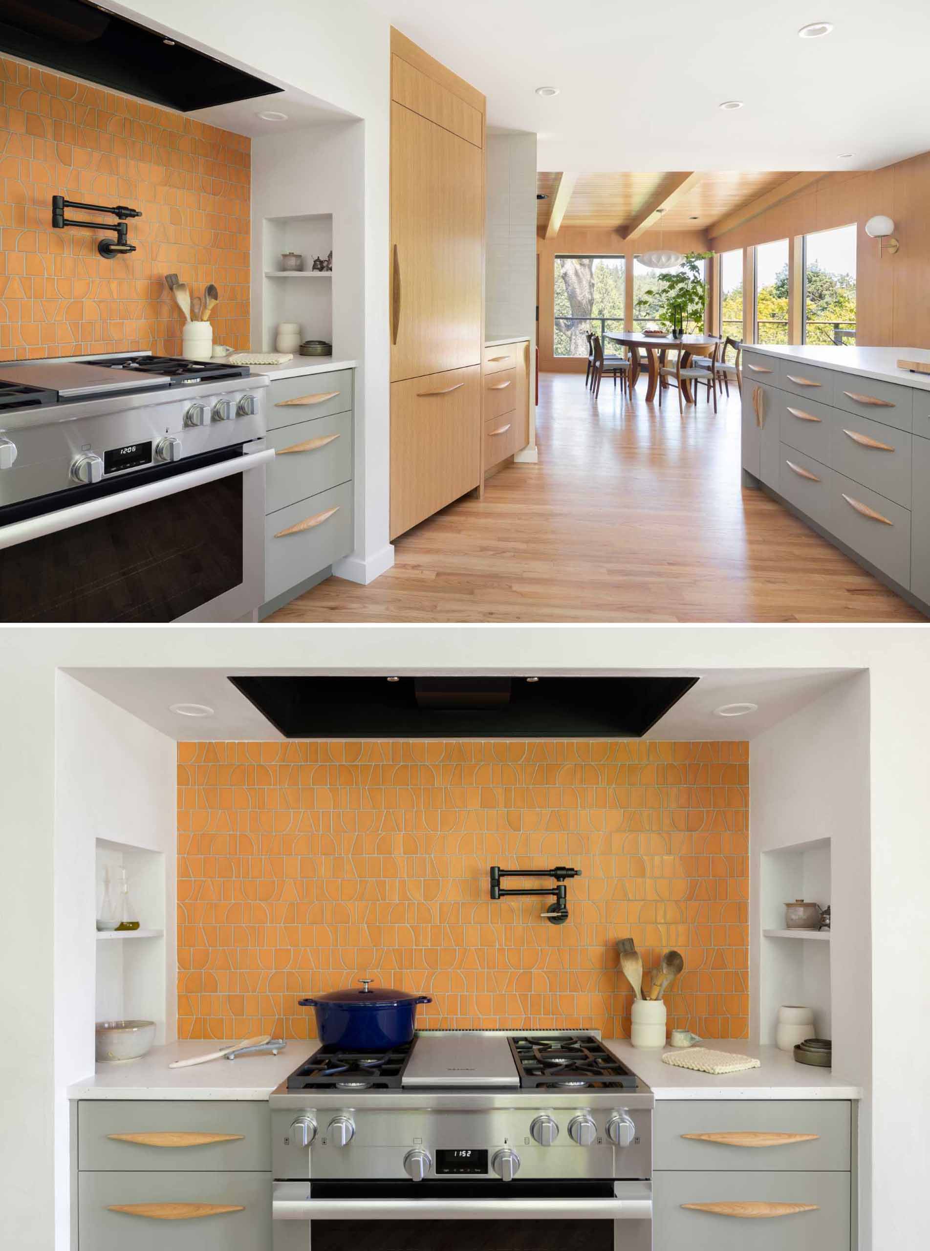 This new open kitchen includes a grey peninsula, grey cabinets, wood details, white countertops, and a tiled backsplash by the stove.