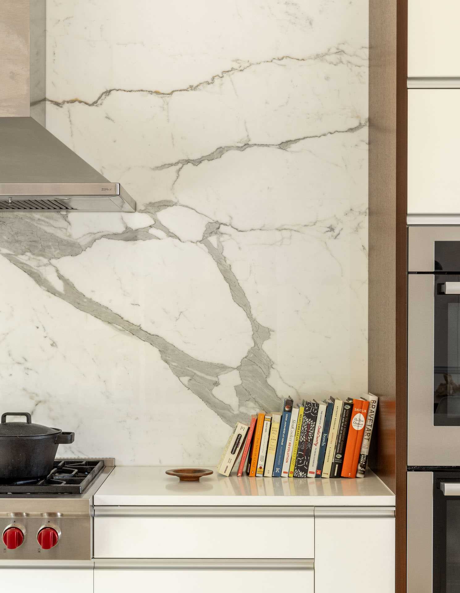 This new bright and open kitchen includes minimalist white cabinets with wood accents.