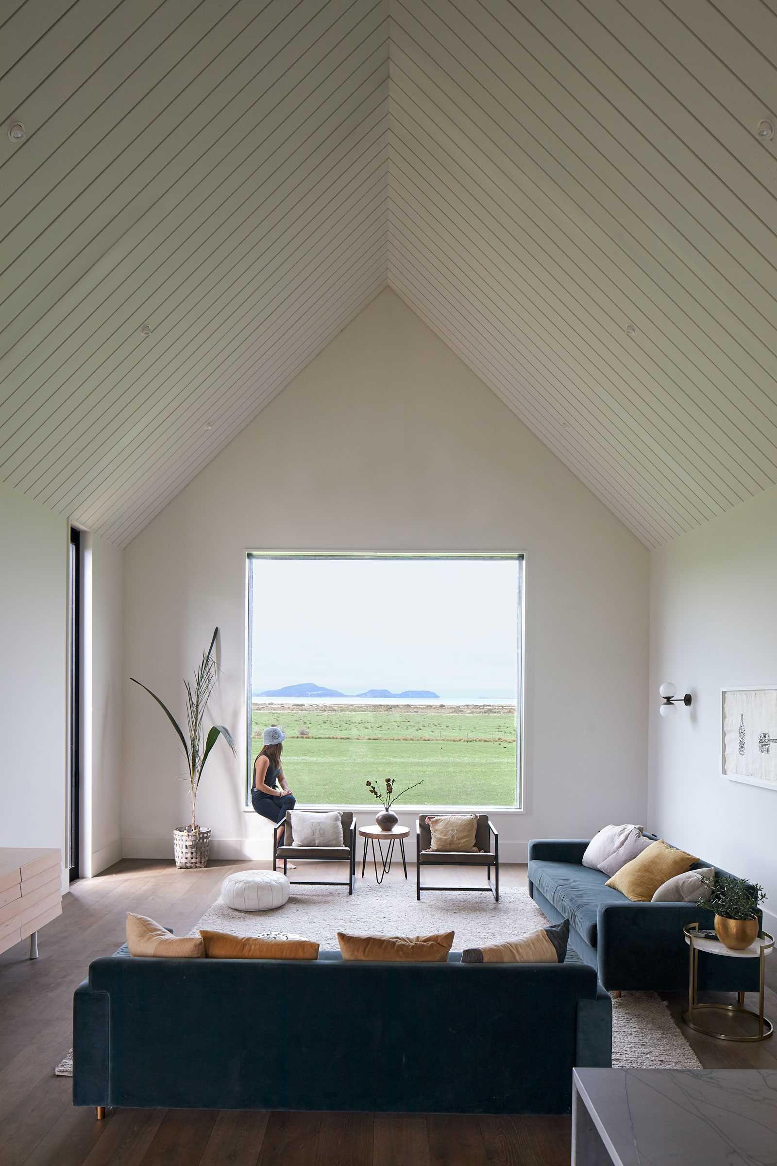 In this modern living room, there's a 22-foot (7m) high ceiling, while the square window perfectly frames the paddock view.