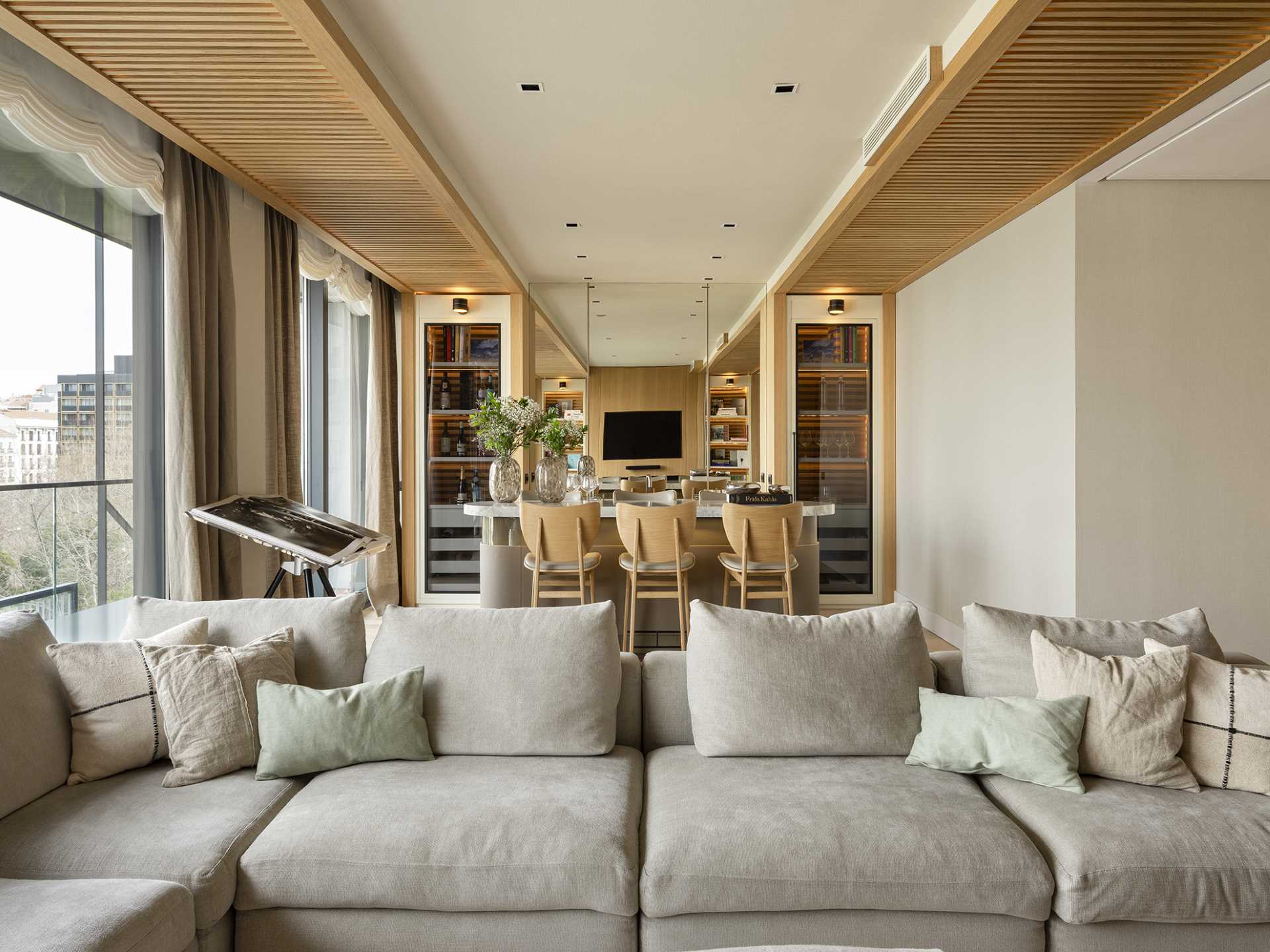 The bar area includes a pair of liquor cabinets on either side of a mirrored section, making the room feel larger than it is.