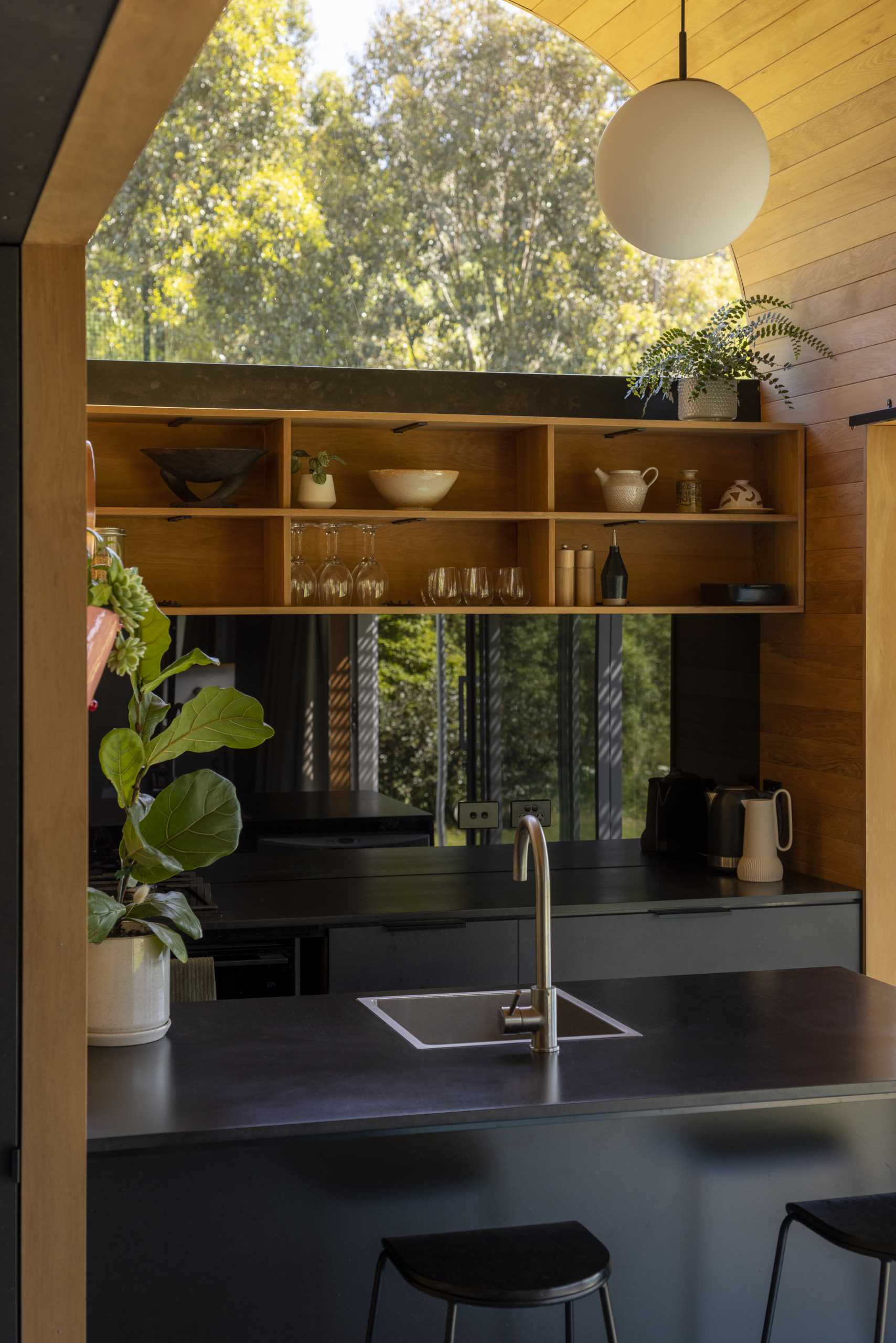 A black and wood kitchen in a small one-bedroom home.