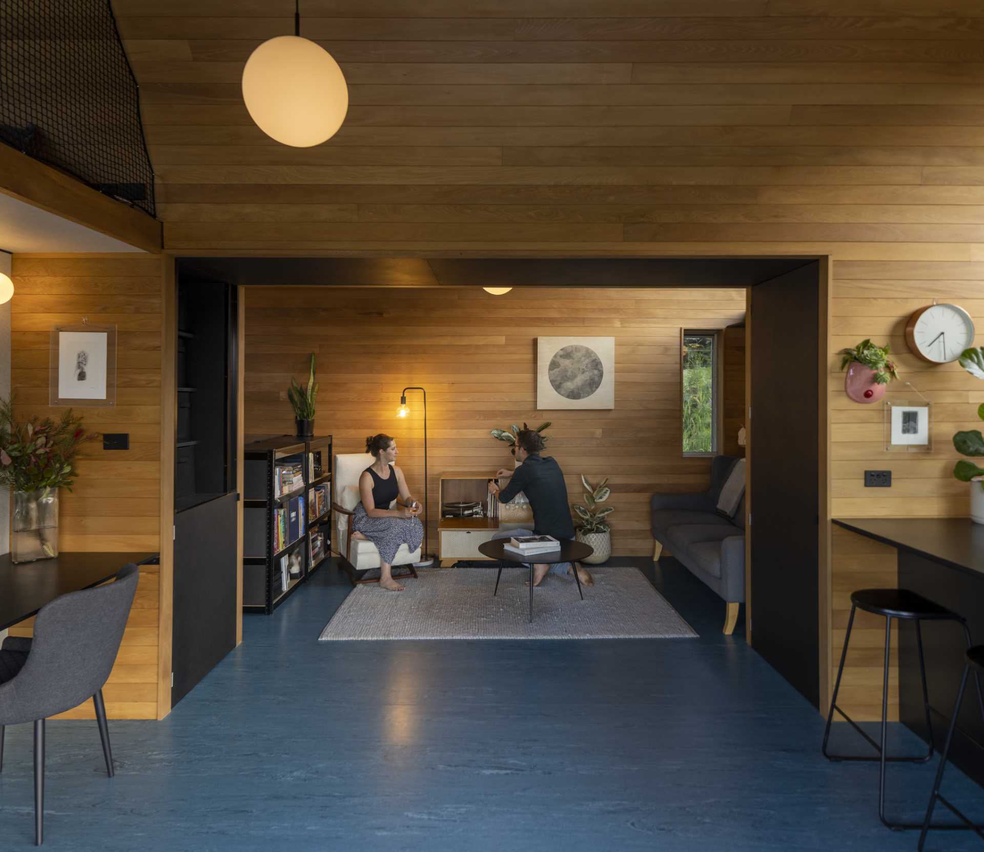 A modern living room with a curved ceiling in a small one-bedroom home.