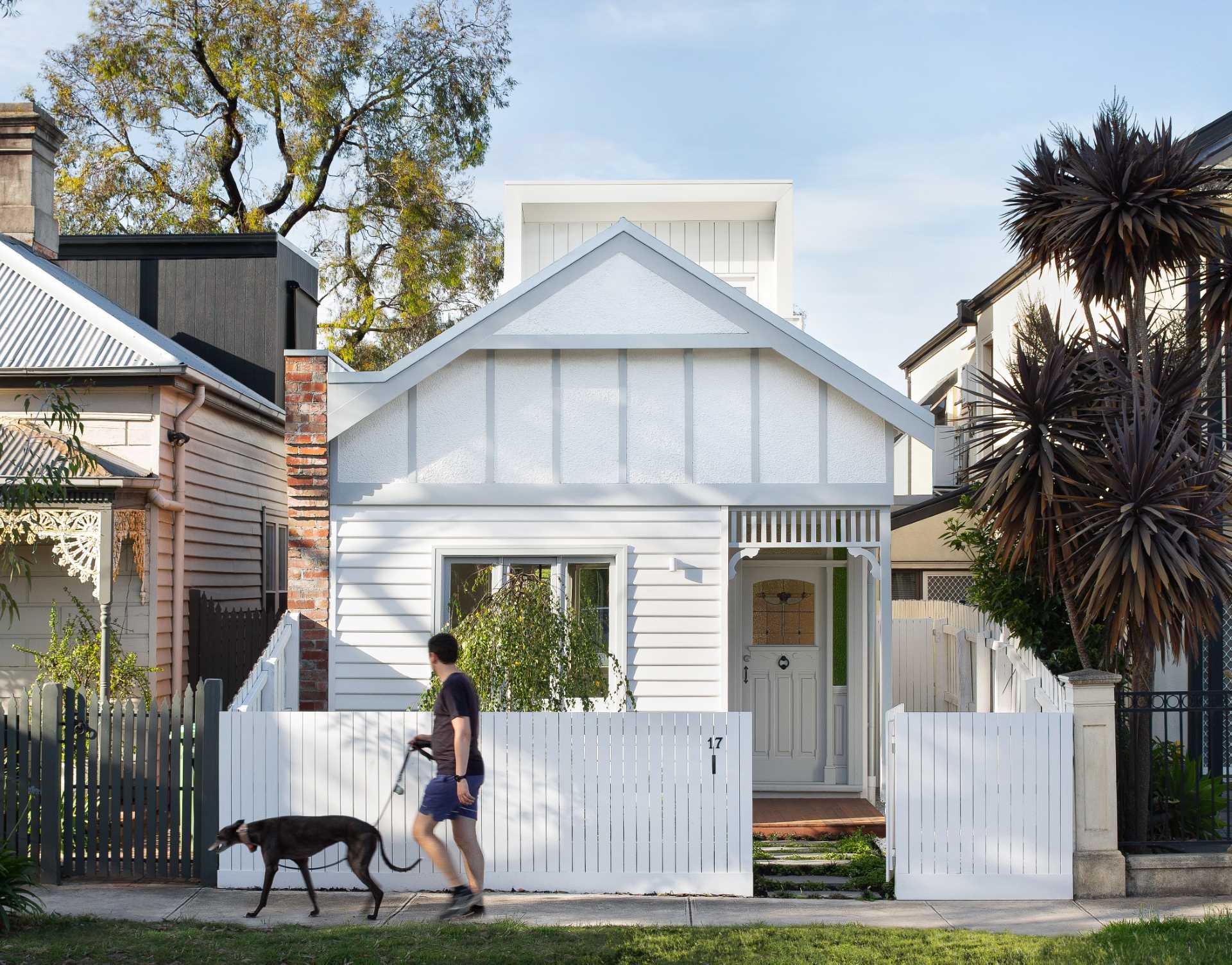 The quaint heritage home fits in with the other homes in the neighborhood, while the new rear extension peaks out from behind.