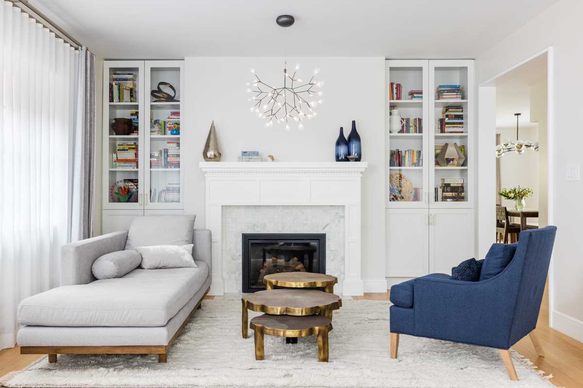 A contemporary living room with new built-in glass cabinets that flank the gas fireplace.