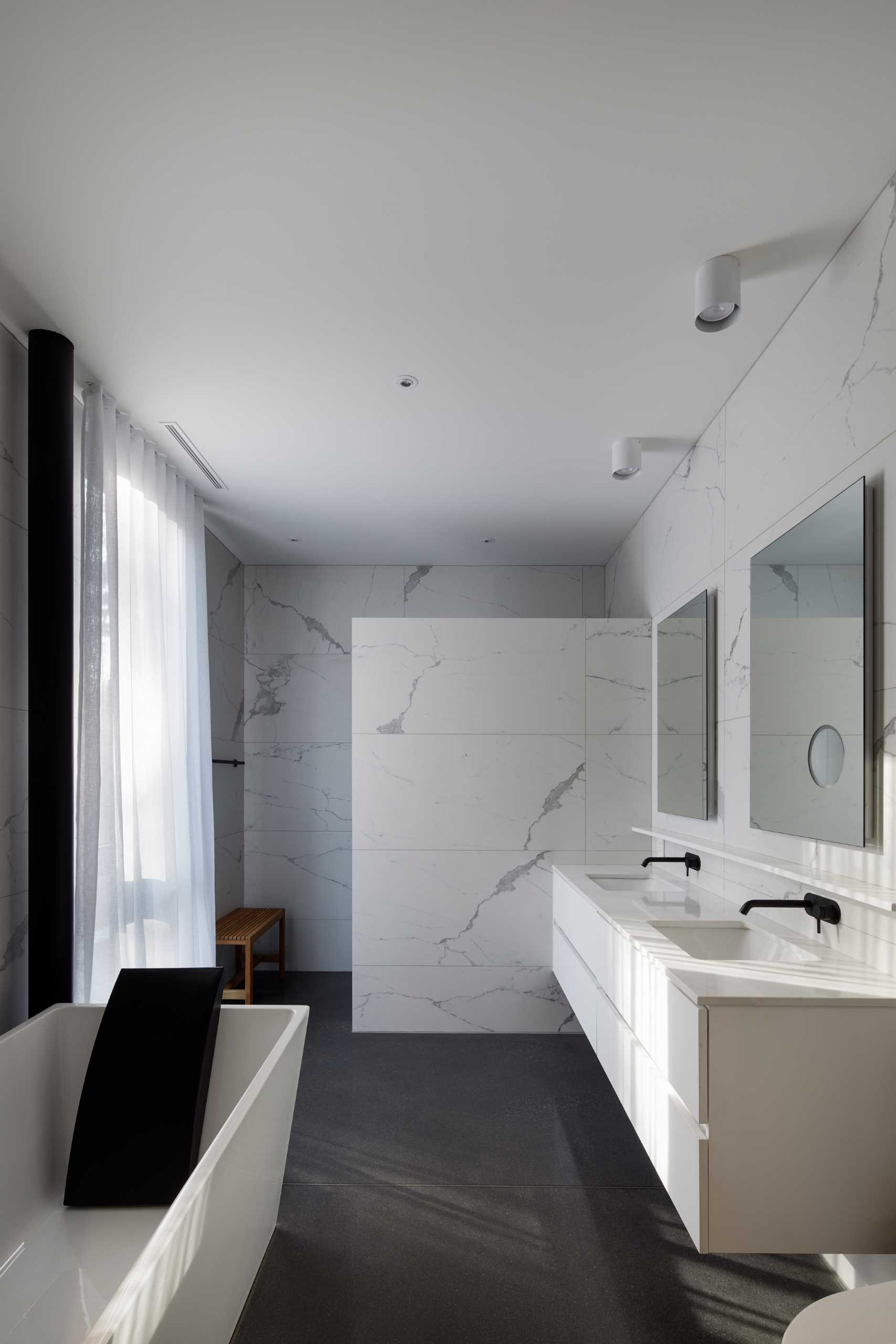A modern bathroom with a black, white, and grey color palette.