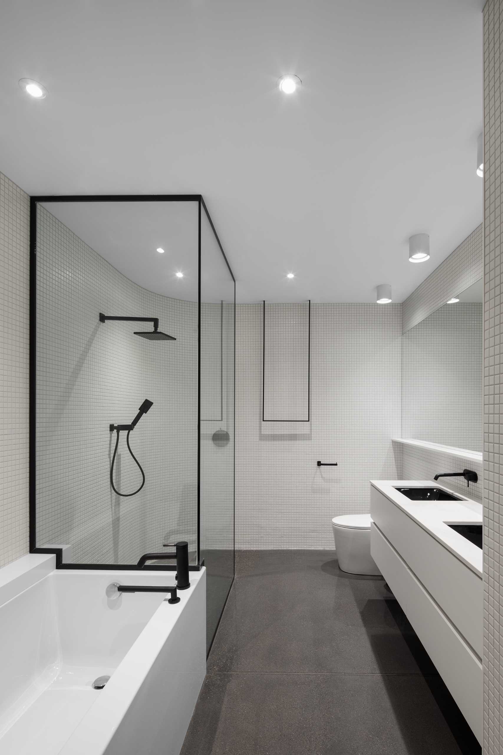 A modern bathroom with a black, white, and grey color palette.