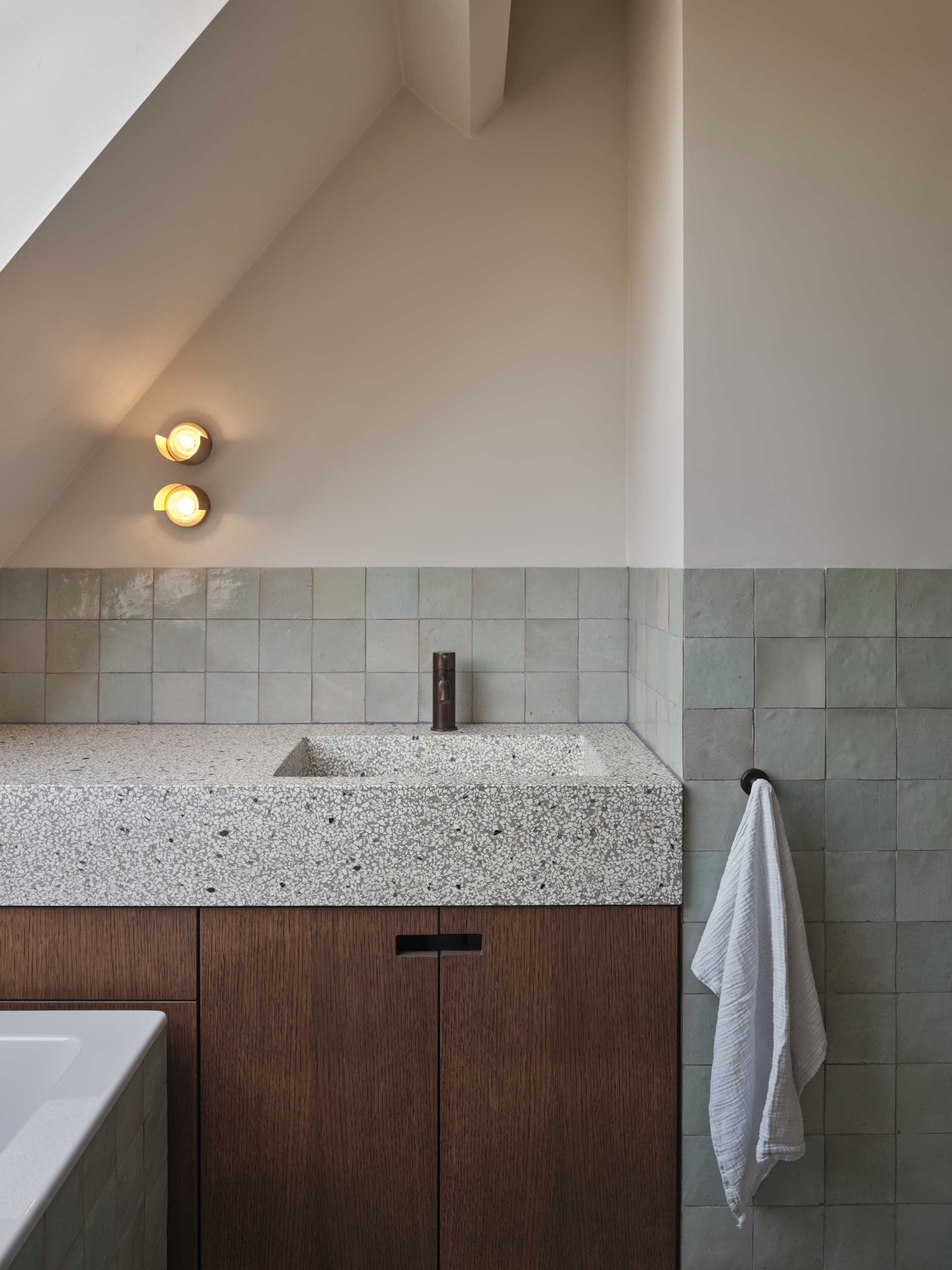 In the children’s bathroom, a more outspoken green color palette was applied over a range of tiles and a terrazzo sink.