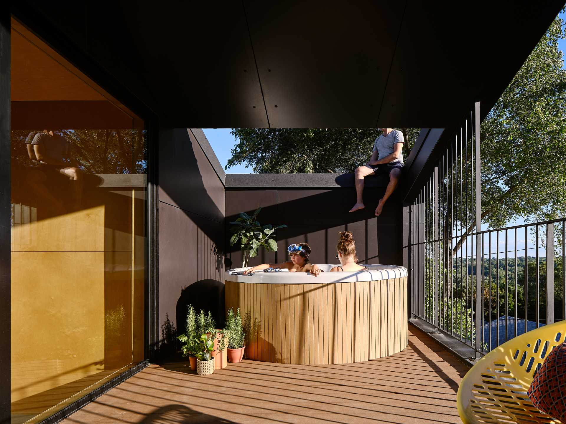 A modern home with a partially covered balcony that has a Japanese soaking tub.