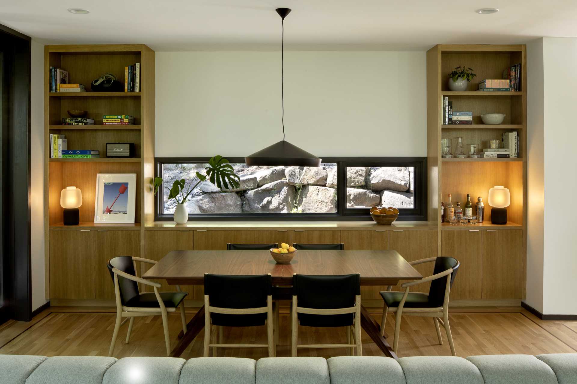 This modern dining area includes a Tom Dixon pendant lamp, as well as chairs from Antonio Citterio’s Jens collection in brushed light oak and thick embossed black leather. 