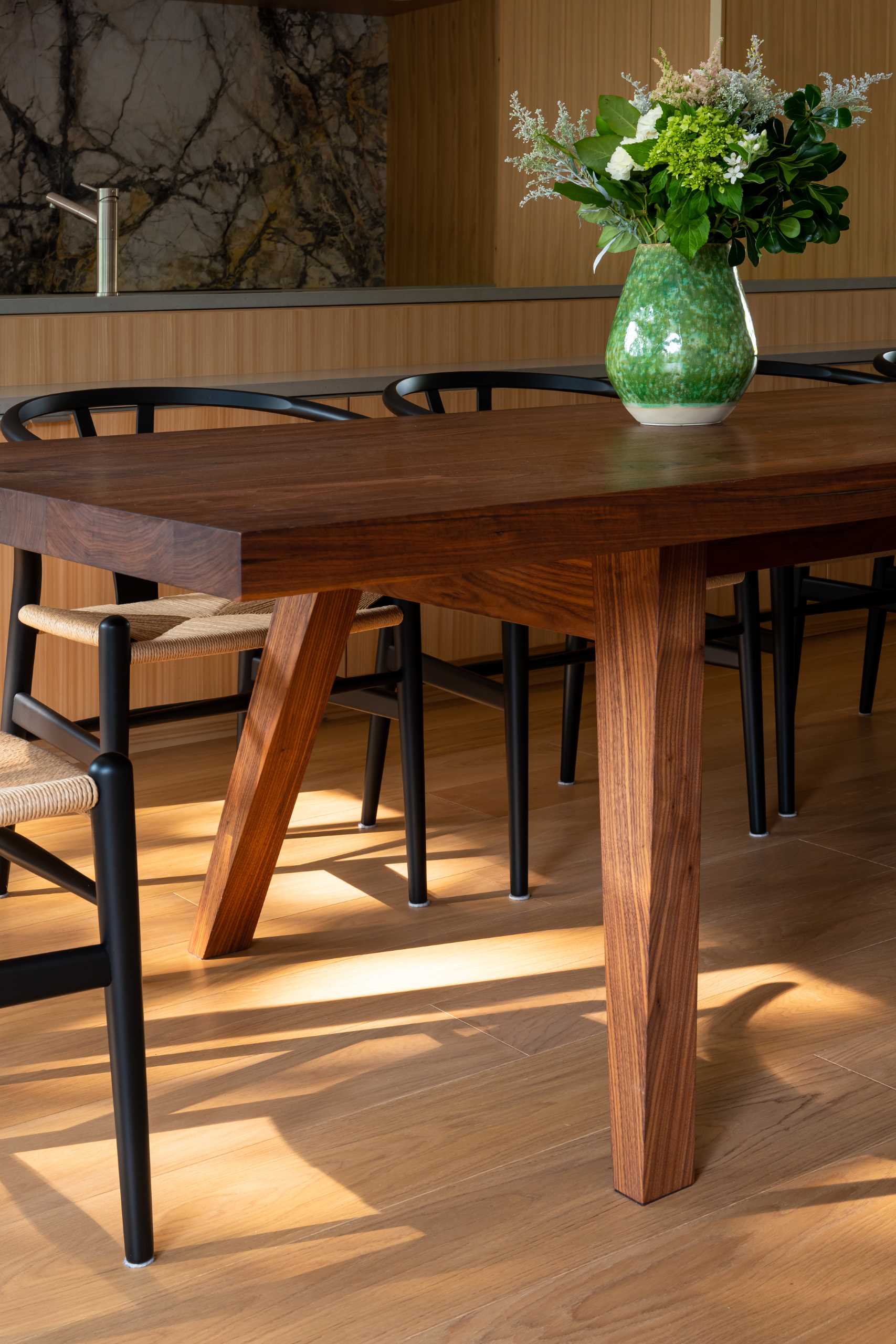 A custom-designed Harvest Table, made from solid Walnut, is a defining feature of the home, and all of the common living areas pivot around this central family gathering place.