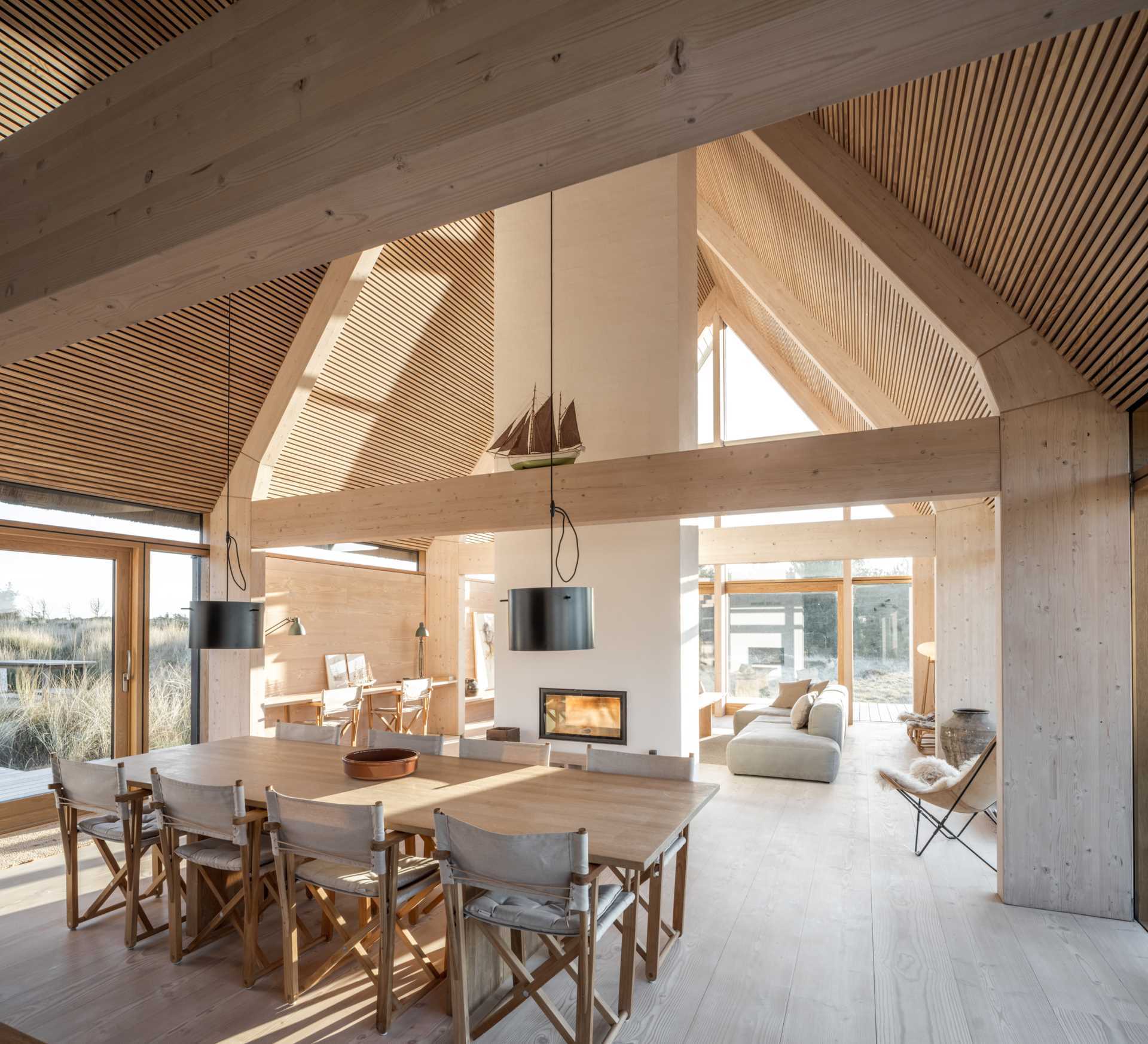A light and natural color palette can be seen throughout this modern house, with a fireplace able to be enjoyed from both sides.