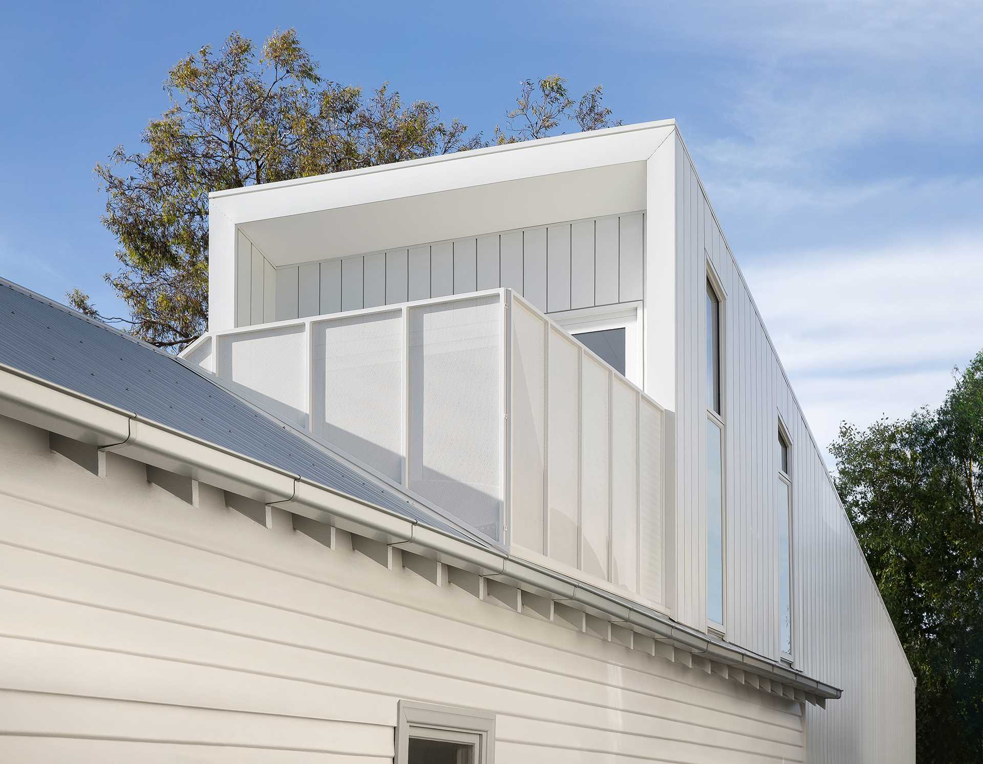 The quaint heritage home fits in with the other homes in the neighborhood, while the new rear extension peaks out from behind.