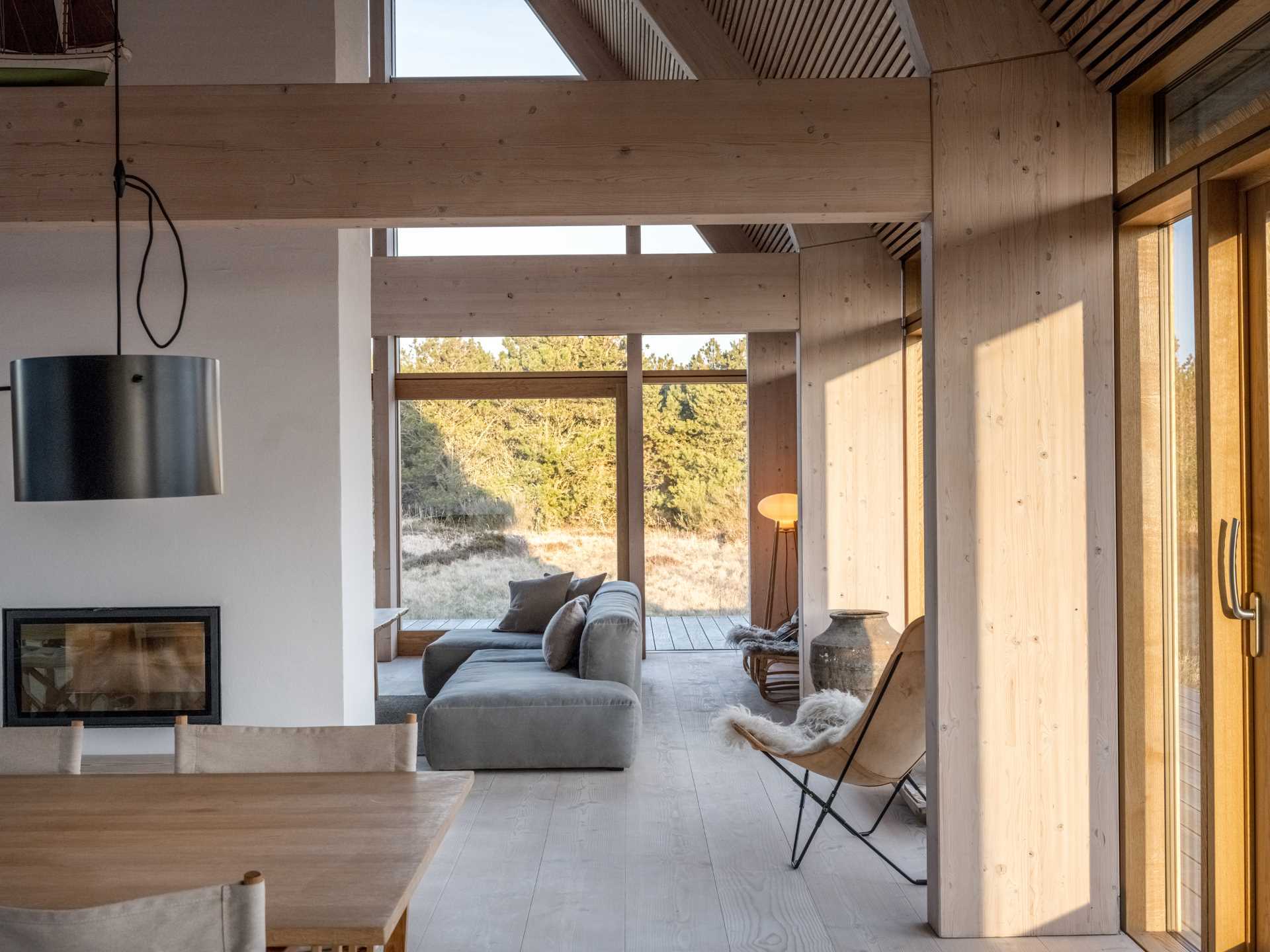 A light and natural color palette can be seen throughout this modern house, with a fireplace able to be enjoyed from both sides.