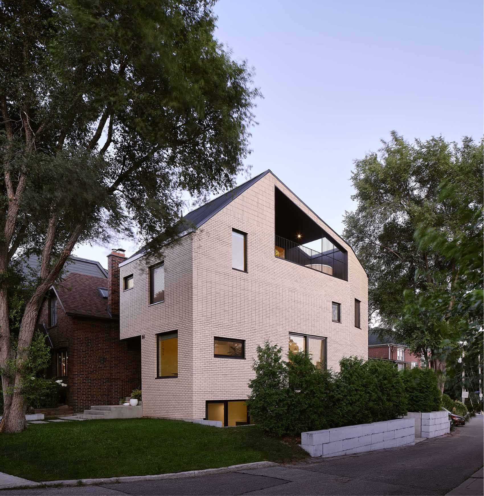 A modern brick home with a partially covered balcony that has a Japanese soaking tub.