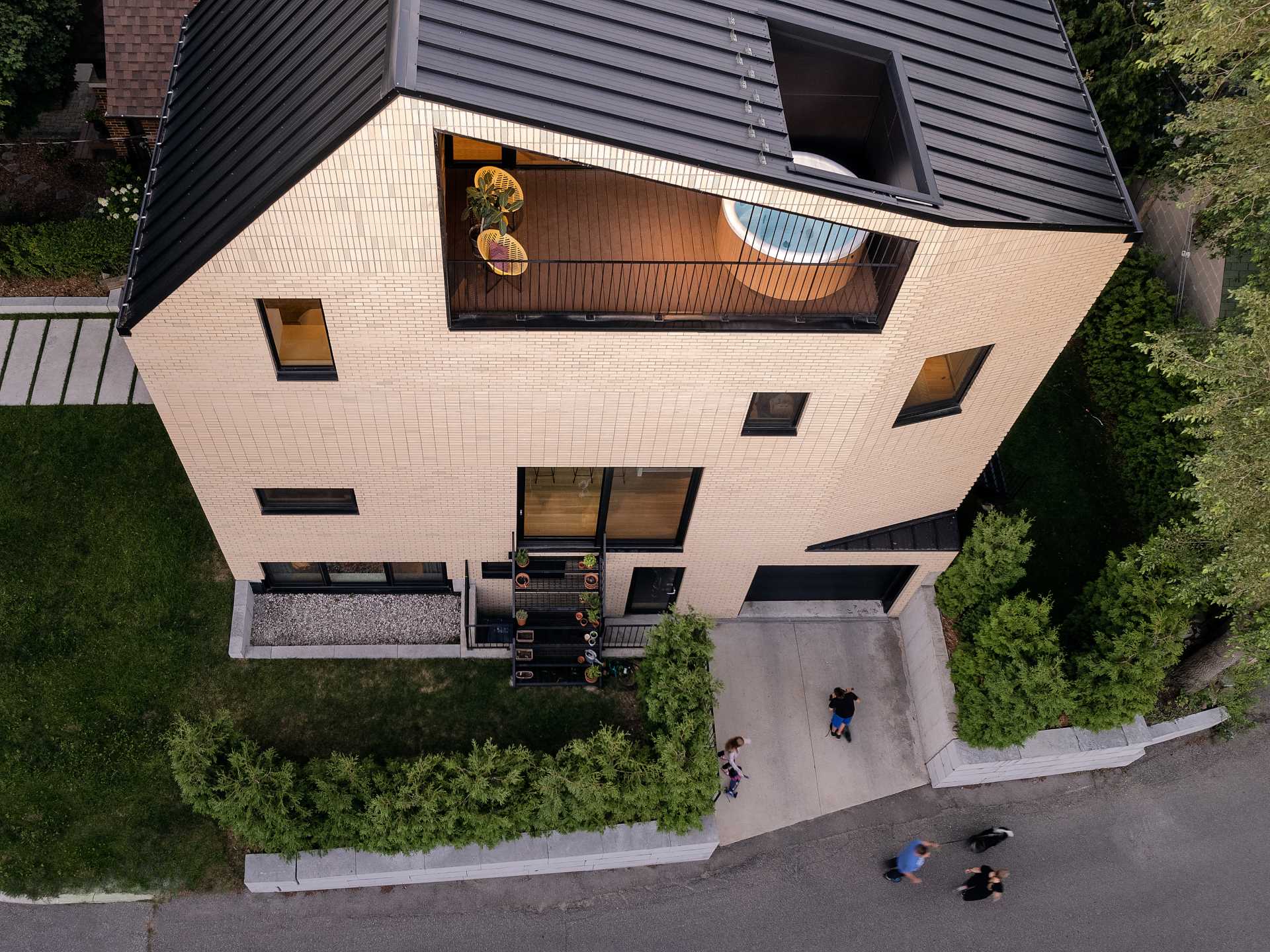 A modern brick home with a partially covered balcony that has a Japanese soaking tub.