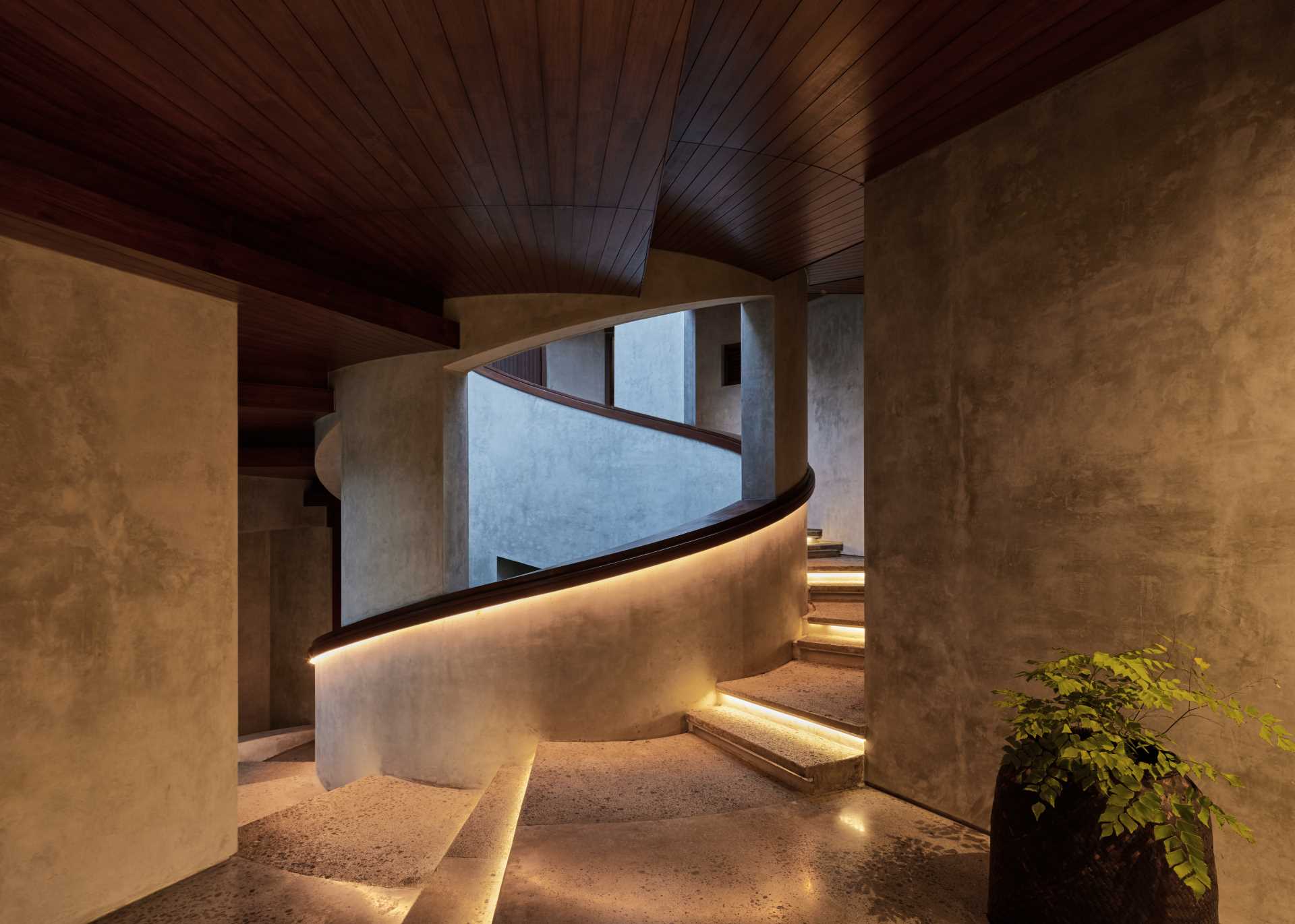 Hidden lighting showcases the design of the stairs and the spiral handrail, which can be seen throughout the home.