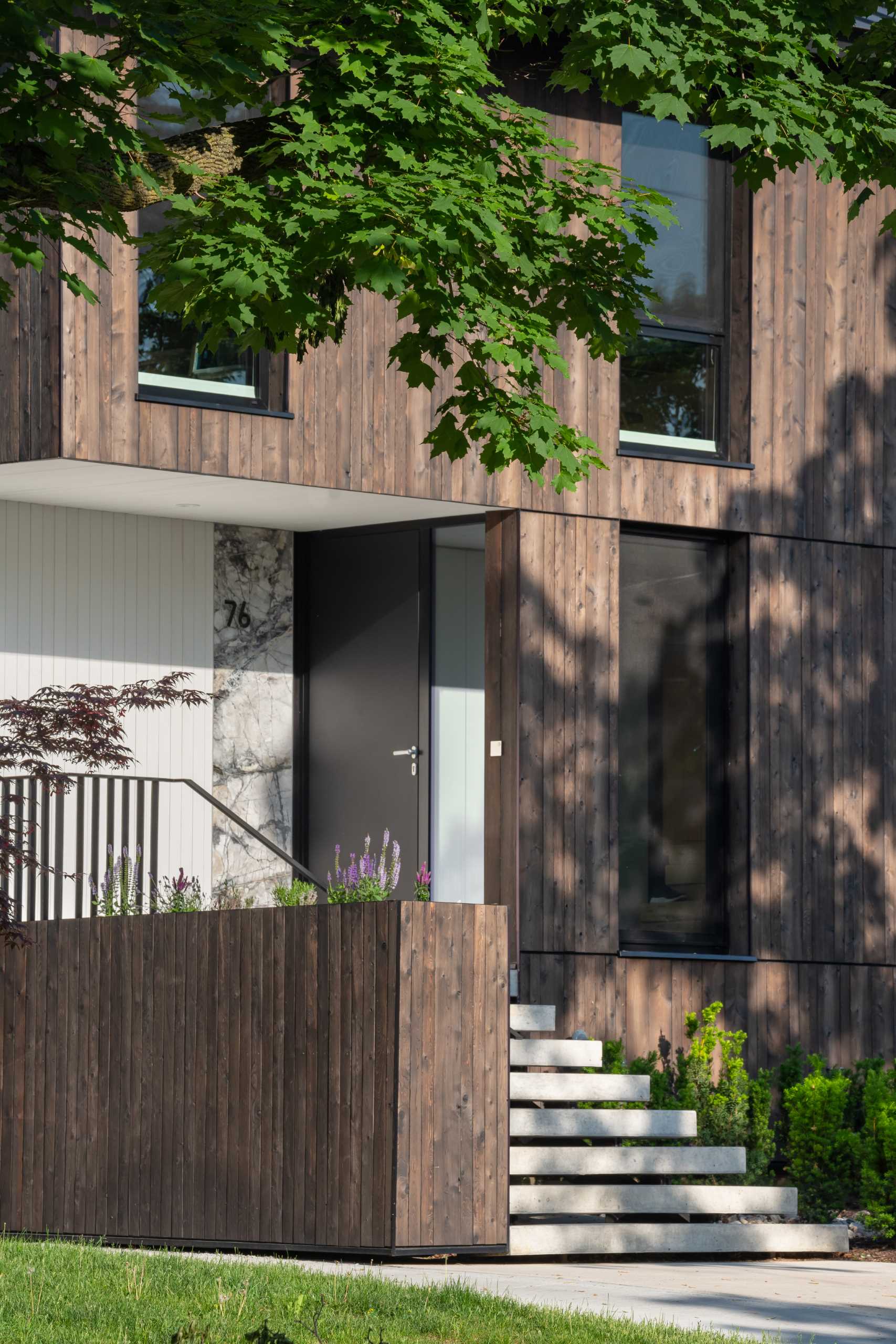 A modern house that's clad in custom charred cedar and has a pitched roof.