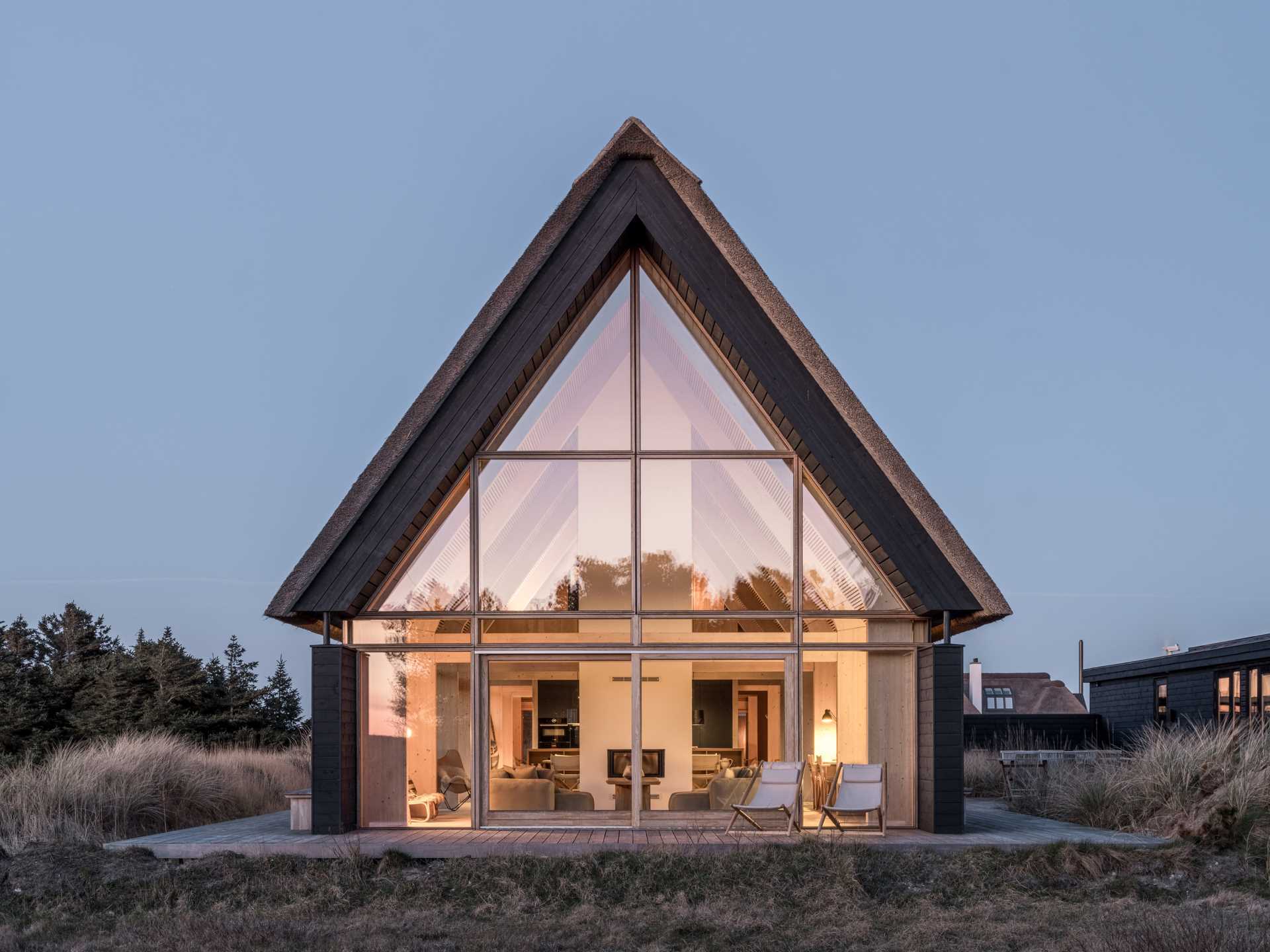 At one end of this home, a wall of windows follows the shape of the exterior lines and provides a view of the interior.