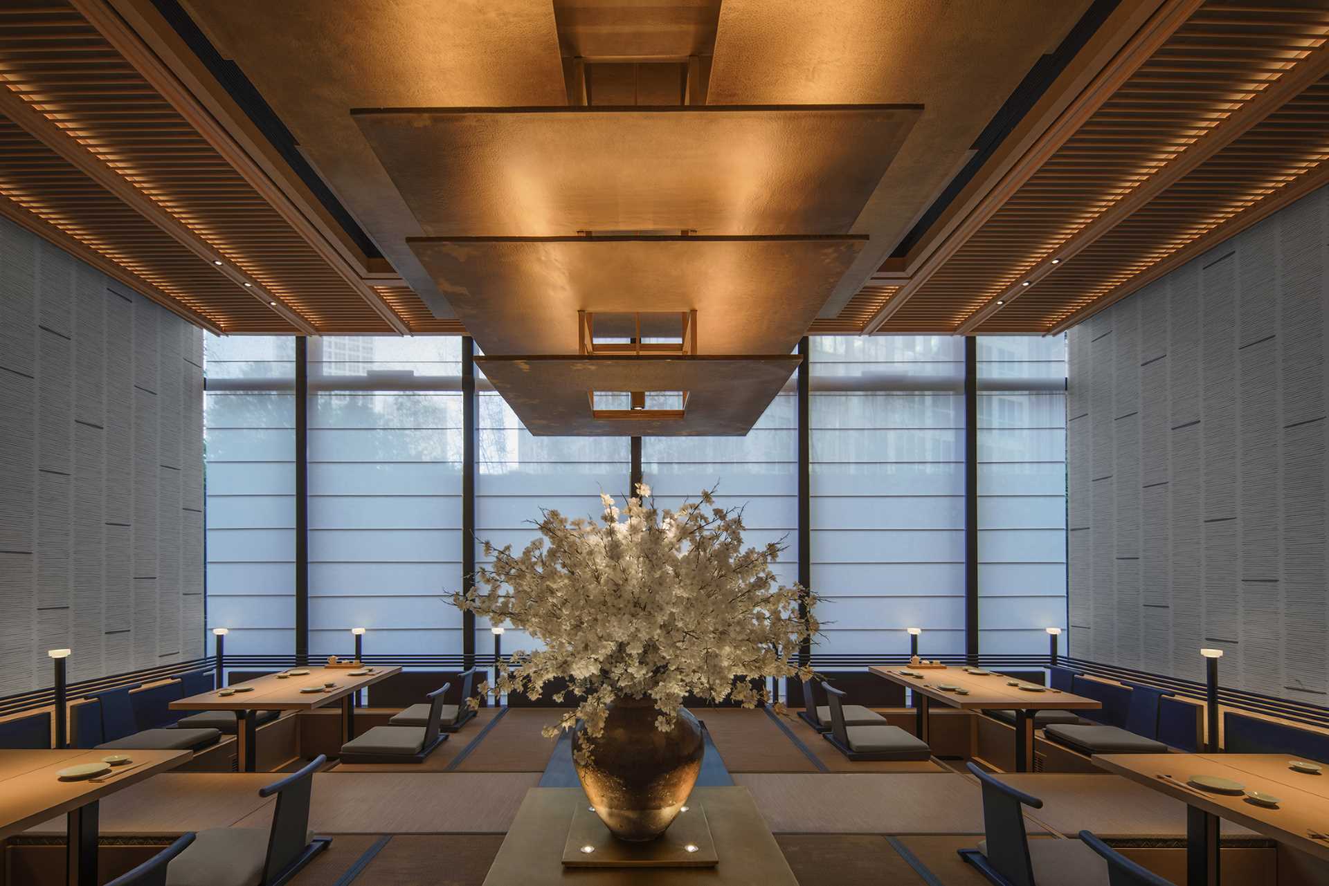 A modern Japanese-inspired restaurant uses wood and lighting to create a warm and inviting atmosphere