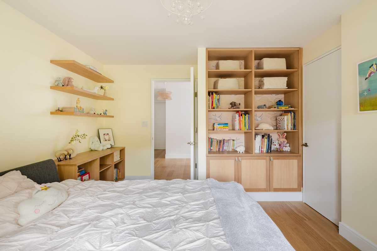 A modern kids room with built-in storage cabinets and shelving.