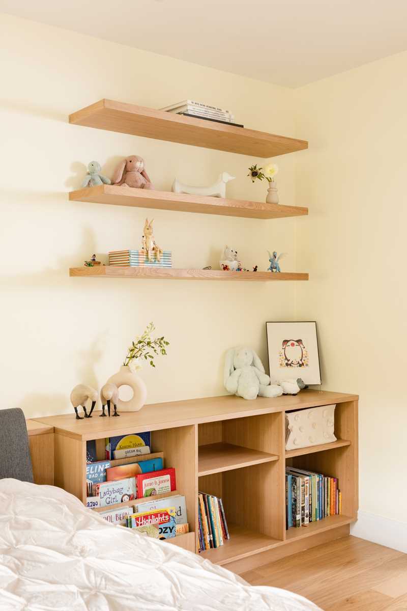 A modern kids room with built-in storage cabinets and shelving.