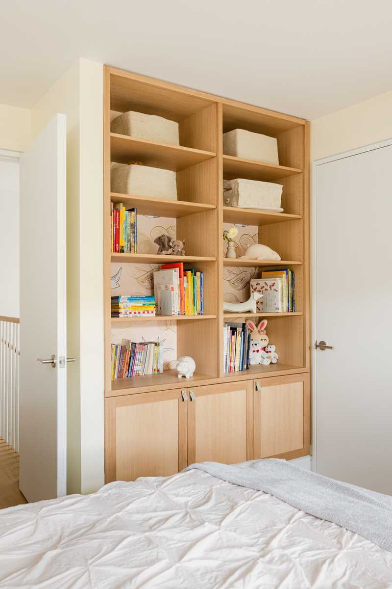 A modern kids room with built-in storage cabinets and shelving.