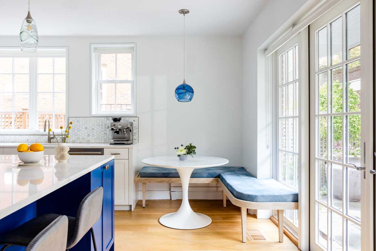 A modern kitchen with a large curved kitchen island with counter seating, and a seating area that wraps around the corner.