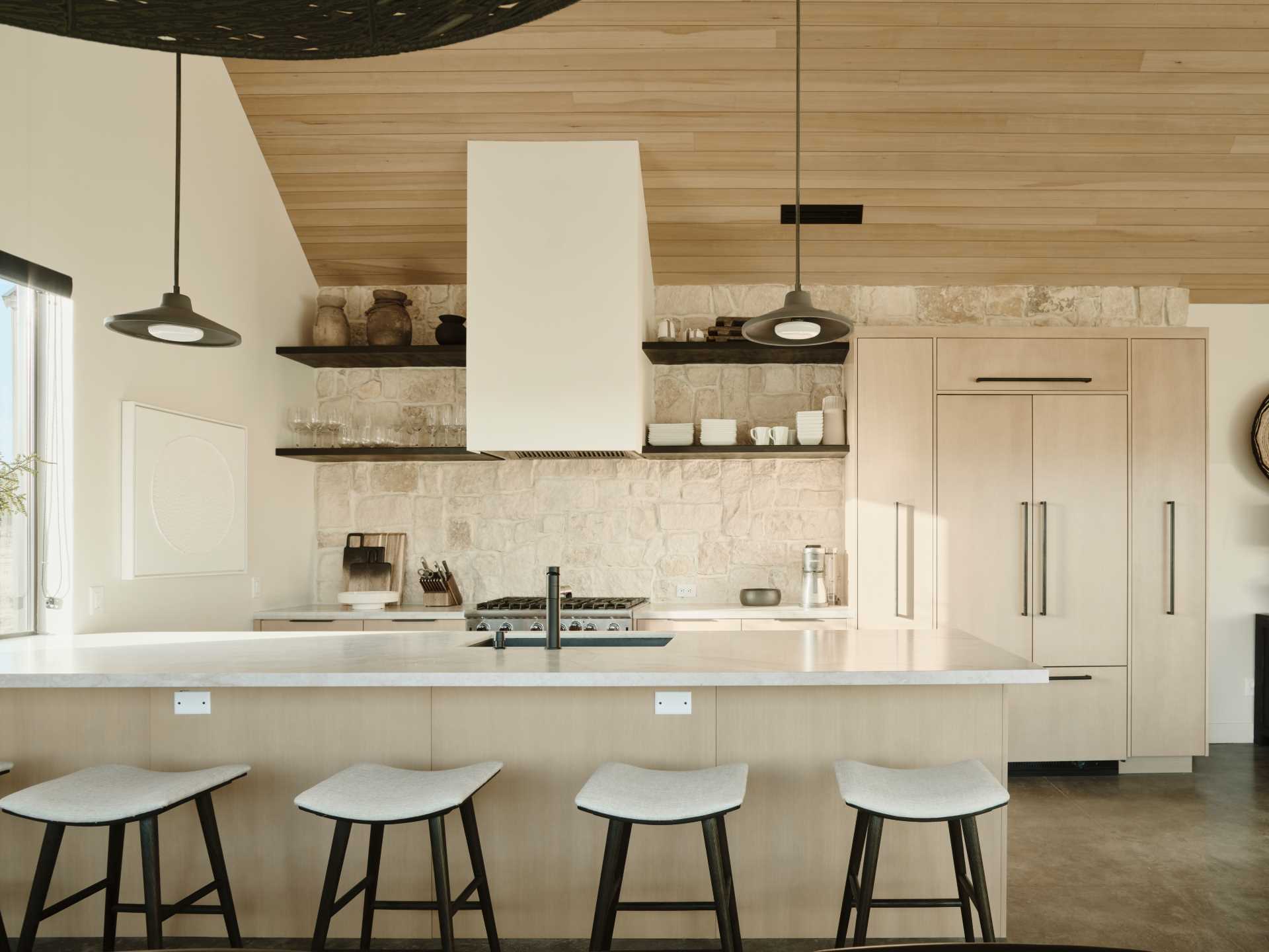 In this kitchen, a stone wall provides a backdrop for the stove and open shelving.