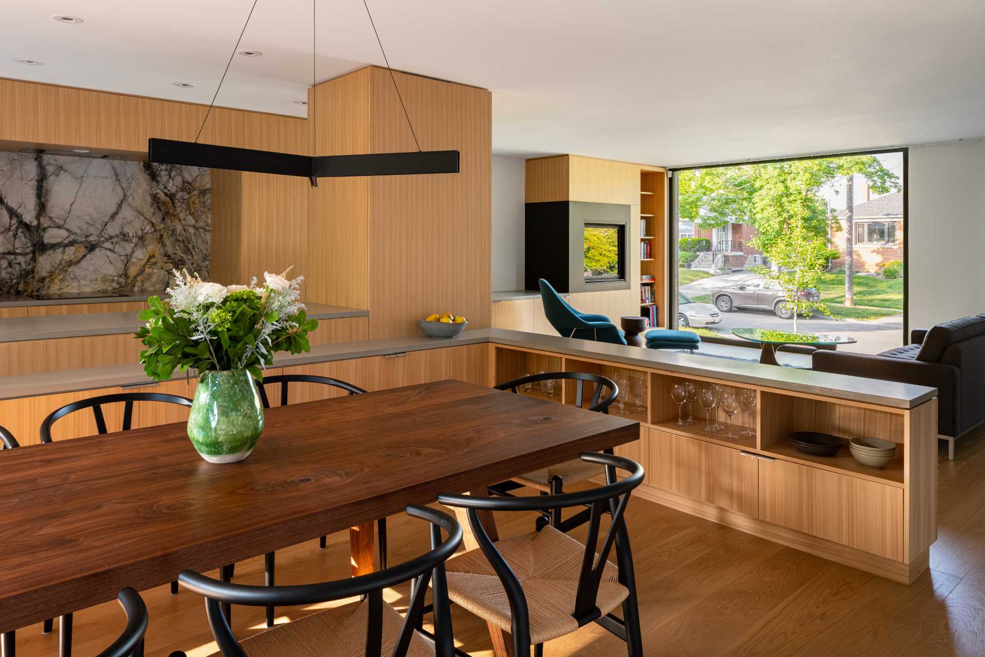 Custom oak cabinetry has been used to separate the dining area, living area, and kitchen in this open interior.