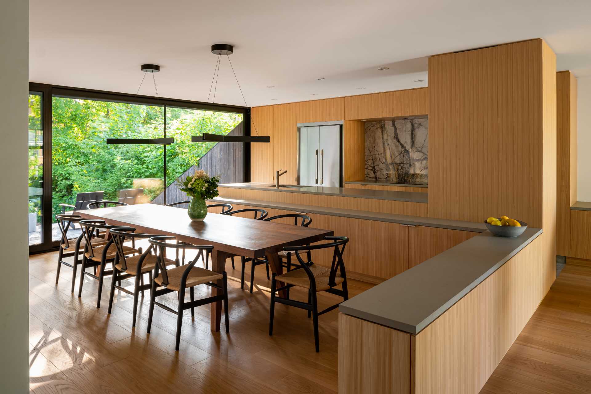 Custom oak cabinetry has been used to separate the dining area, living area, and kitchen in this open interior.