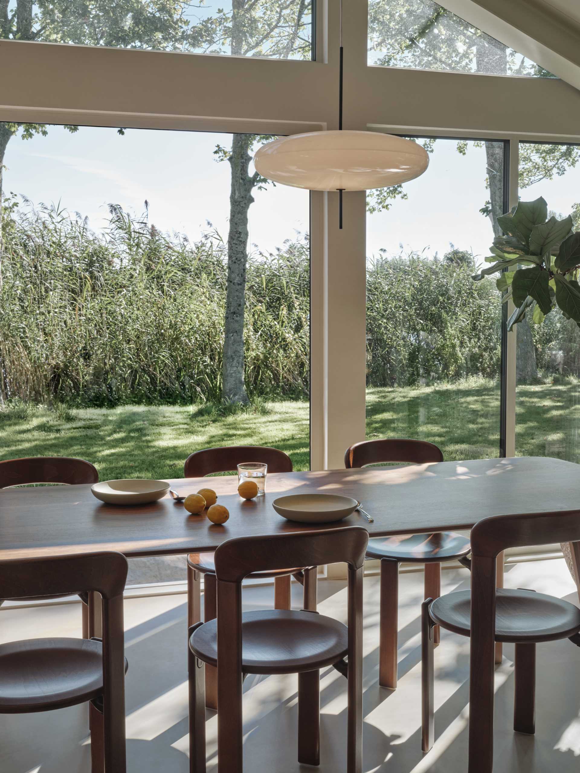 This open plan dining area includes a wood table and matching chairs that complement the nearby kitchen cabinets.