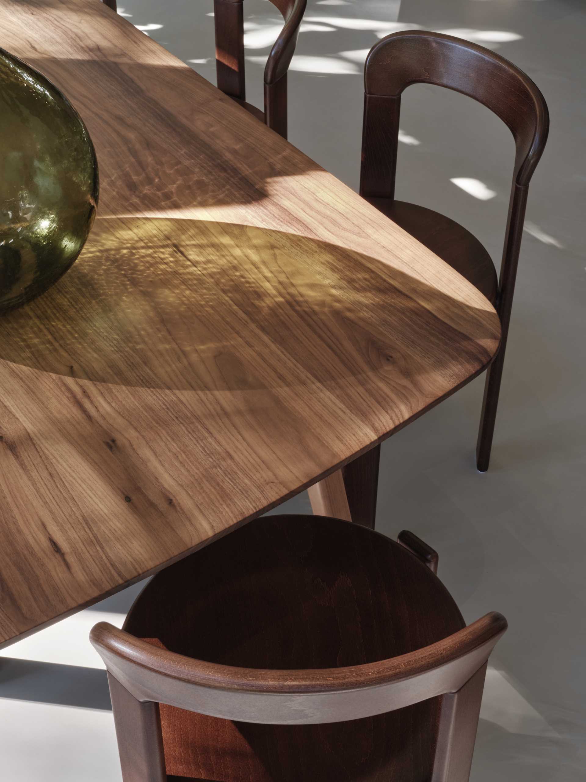 This open plan dining area includes a wood table and matching chairs that complement the nearby kitchen cabinets.